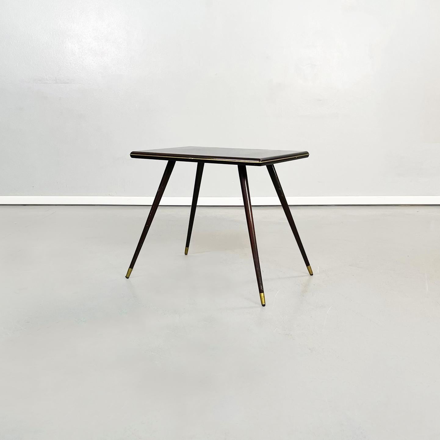 Mesa de centro rectangular italiana de mediados de siglo en madera y latón, años 50
Mesa de centro rectangular de madera oscura brillante. La parte superior es rectangular con bordes redondeados, perfilada por una fina línea de latón. Las patas