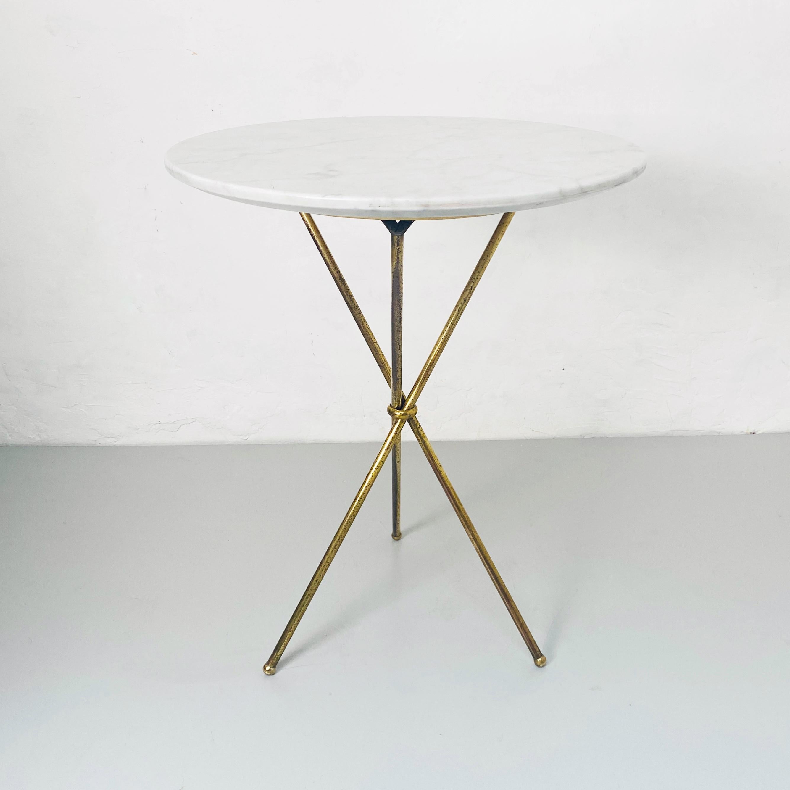 Italian Mid-Century Modern round marble and brass coffee table, 1960s.
Coffee table with round white marble with gray veins and brass legs crossed and welded around a knot.

Round coffee table in marble and brass, 1960s
beautiful small table,