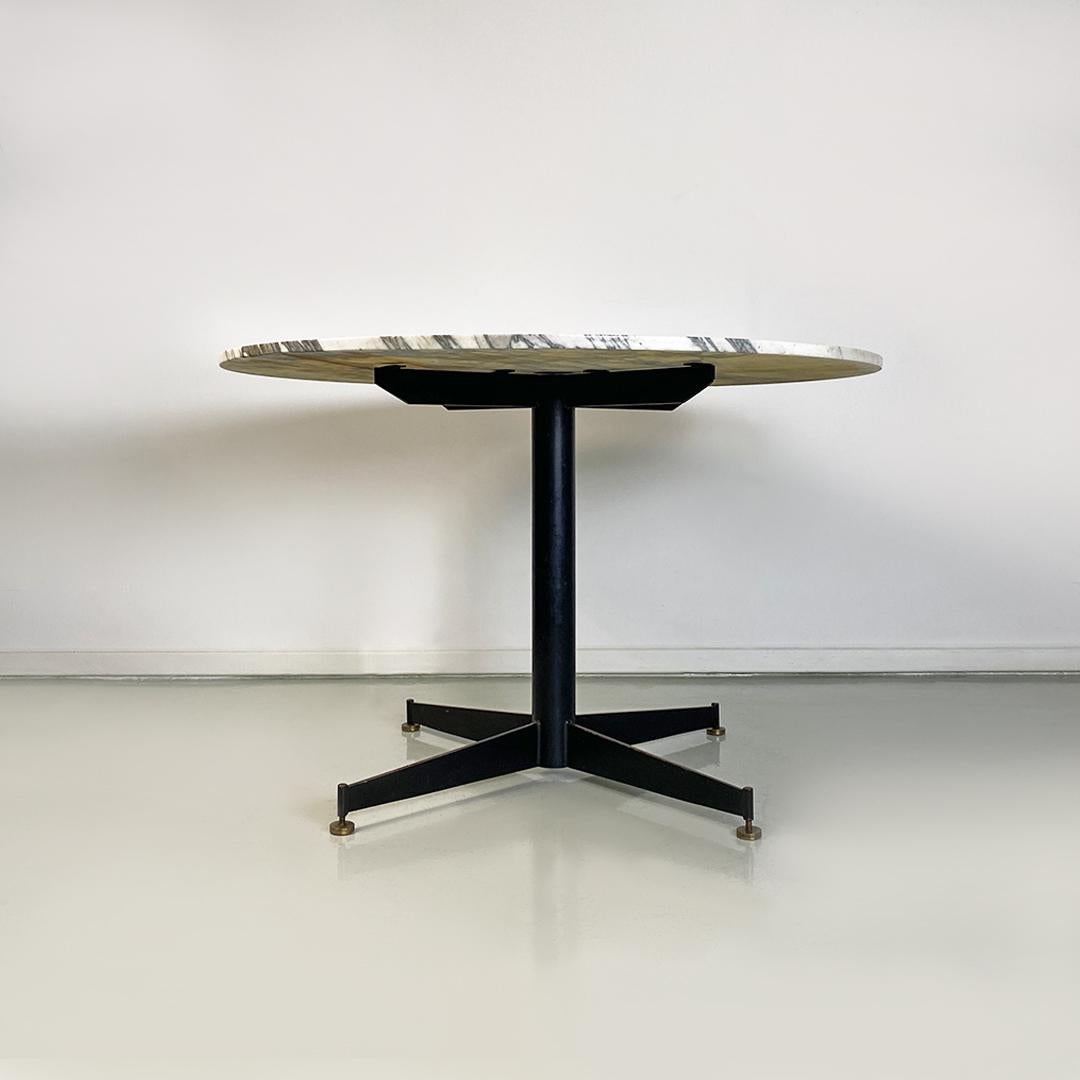 Italian Mid-Century Modern round grey and white marble, black metal and brass details dining table, 1950s.
Round dining table, with metal base with four spokes and brass tips, with two-centimetre-thick marble top with white background and gray