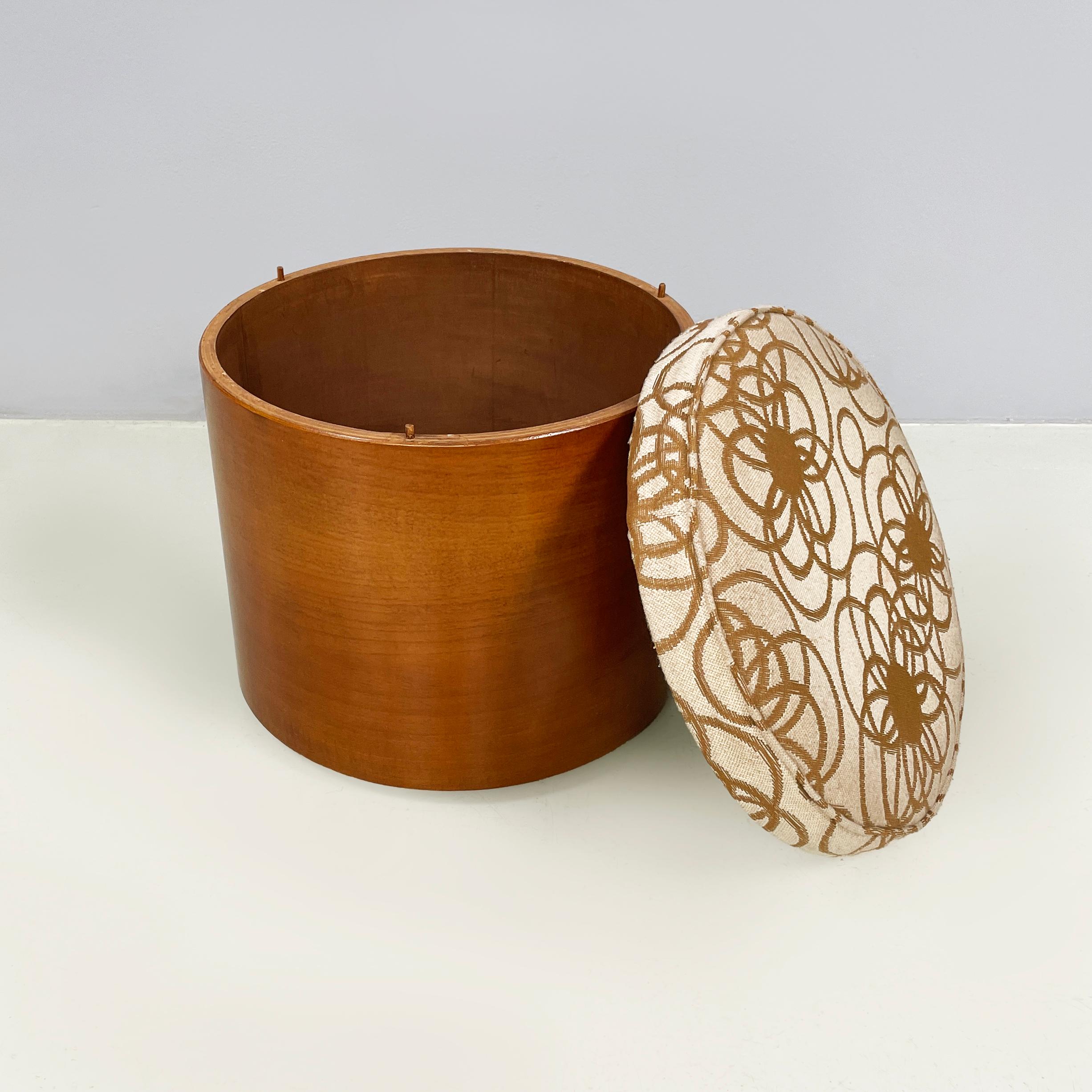 Pouf rond avec compartiment caché de Pozzi, années 1960
Pouf de table ronde en tissu et bois. L'assise est paddée et recouverte d'un tissu de fond beige à décor floral stylisé marron. Le siège est amovible et laisse apparaître le compartiment