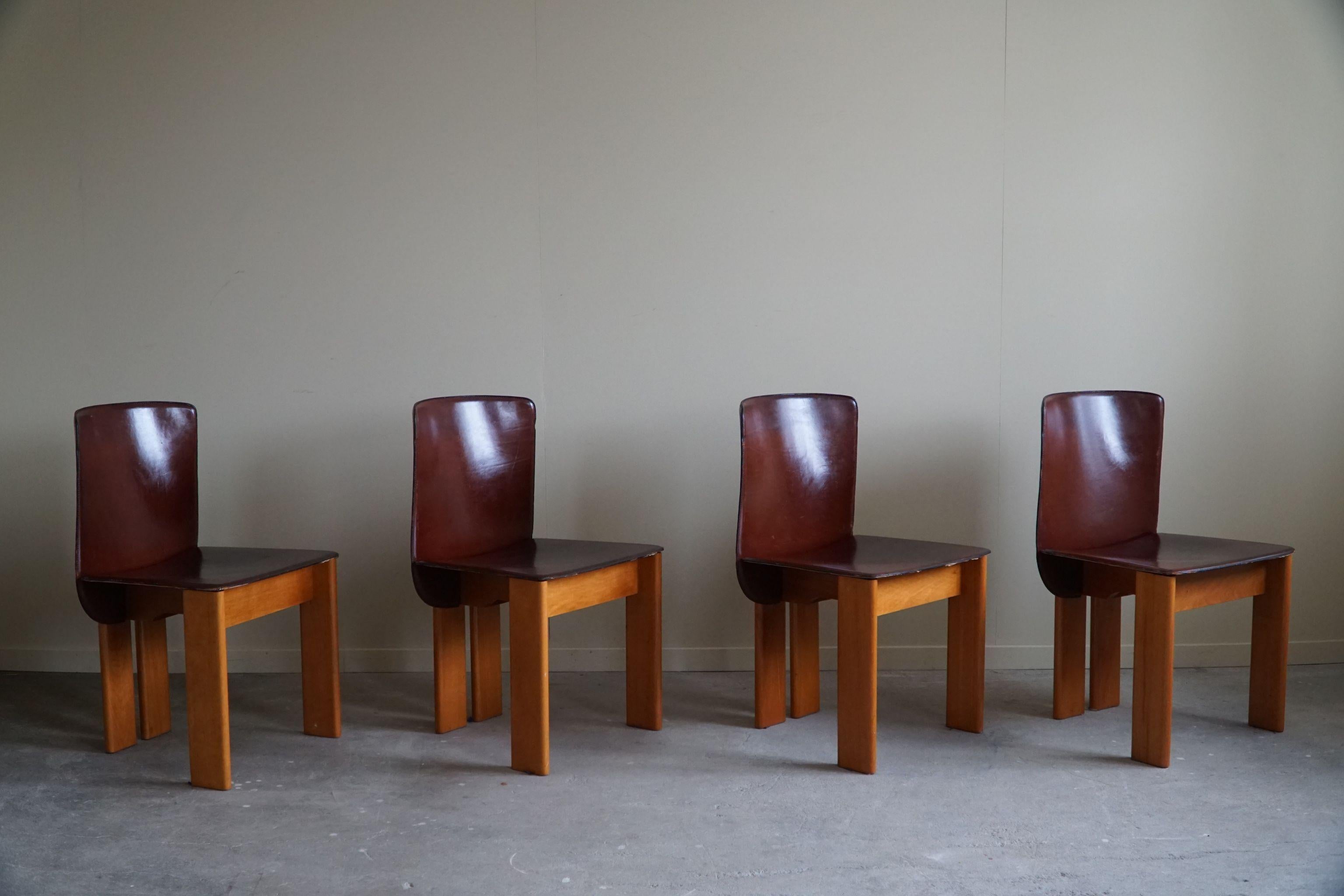 An amazing set of 4 dining chairs in a deep brown colored leather with a solid wooden frame. Made in Italy, in the style of the Italian designer Tobia Scarpa. Made in the 1960-1970s.

Such beautiful lines and a warm patina that complement the