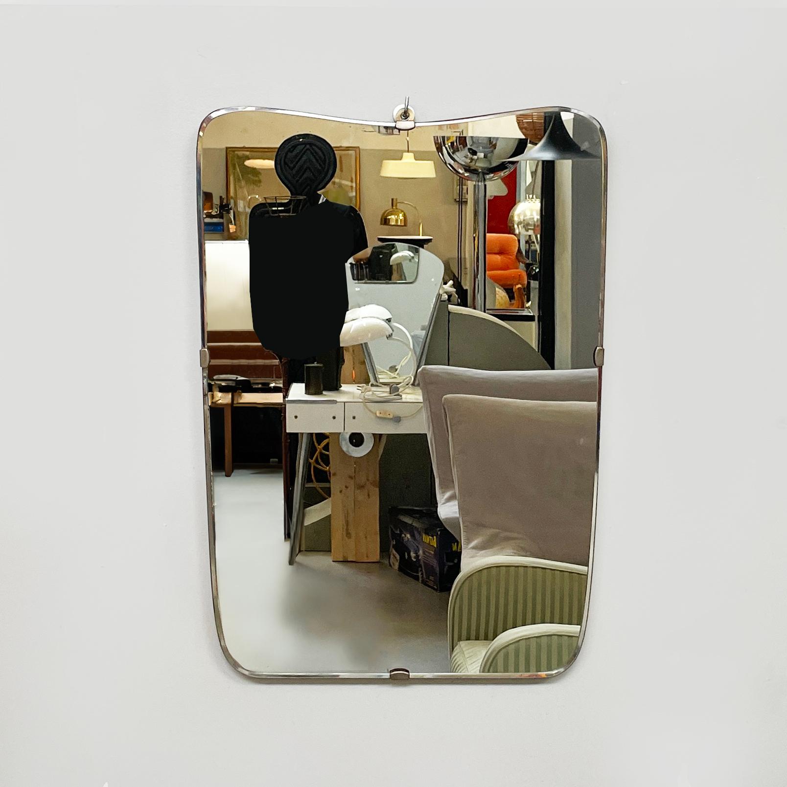 Italian mid-century modern Shaped wall mirror in wood and metal, 1950s
Shaped wall mirror with rounded corners. The wooden structure narrows slightly in the lower part. The mirror part is fixed to the structure via four metal hooks. 
1950s. 
Vintage