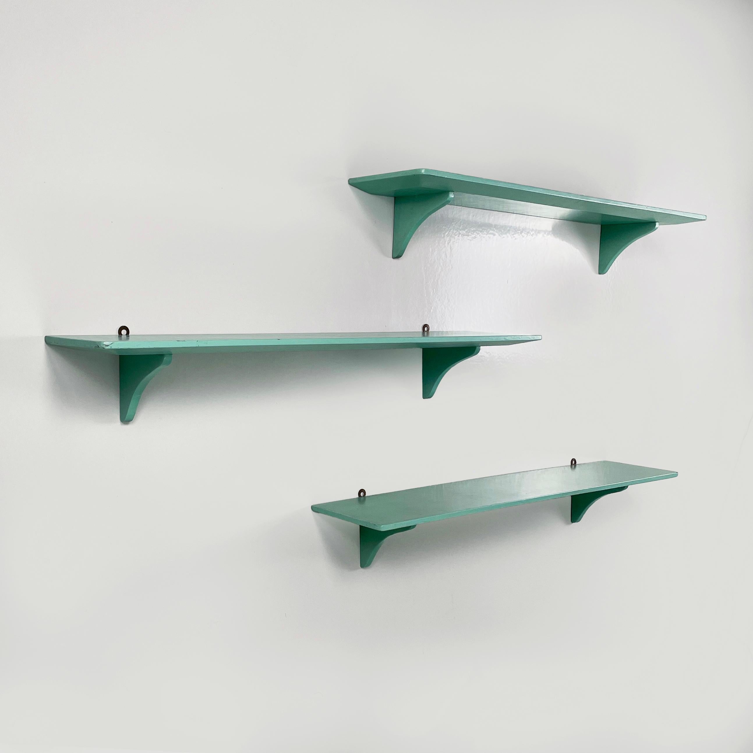 Italian mid-century modern Shelves in aqua green wood, 1970s
Set of 3 wooden shelves painted in aqua green (or Tiffay). The top is rectangular with two rounded corners. Under the top there are two wooden shaped supports. There are two metal support