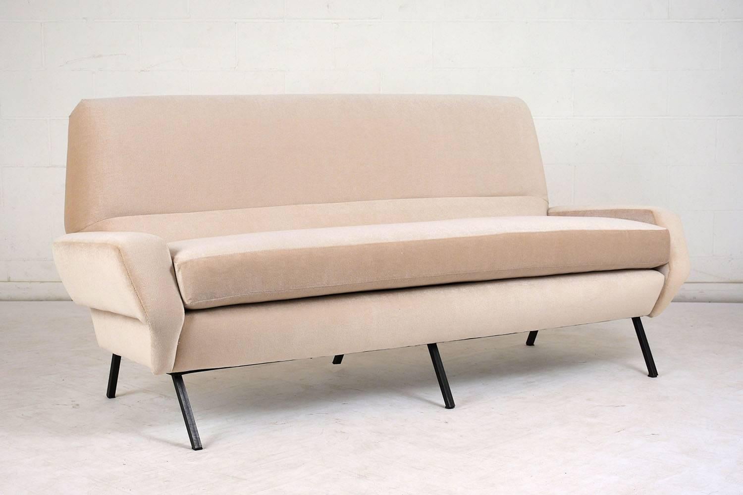 This 1960s Italian Mid-Century Modern style sofa has been completely restored with new ivory colored mohair upholstery. The soft curves of the sofa are accented by stitching accents and black iron legs. The seat features a very comfortable cushion.