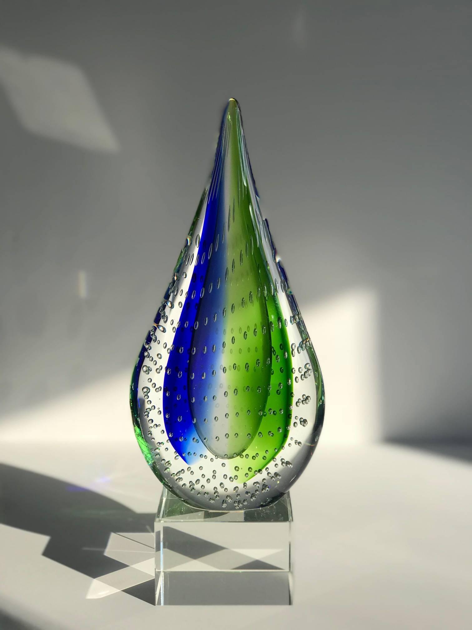 Teardrop sculpture made of Murano bubble glass with a lucite pedestal base. Features Sommerso technique whereby vibrant colors of green and blue glass are submerged within clear blown glass. Can be used as decorative sculpture, or as a bookend or