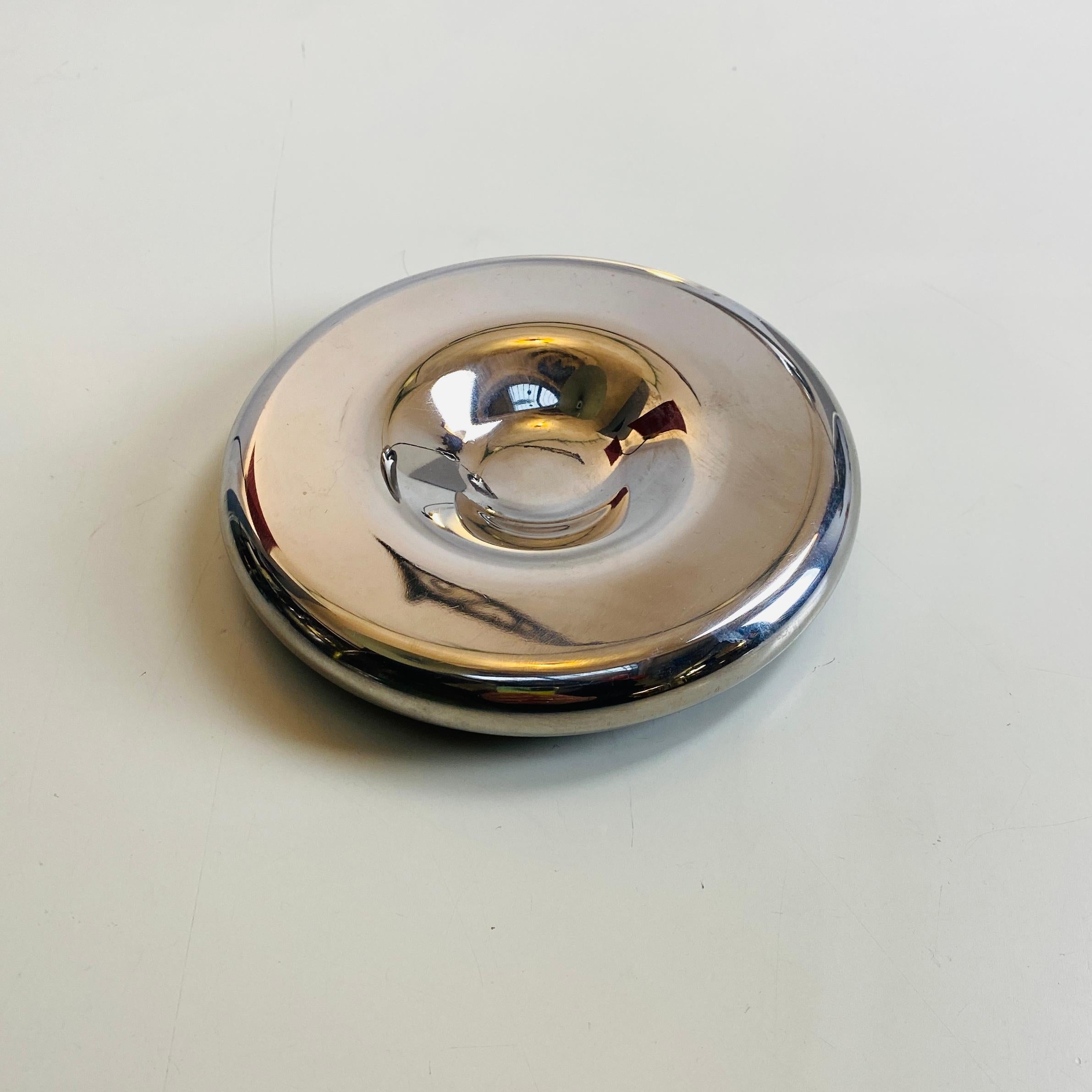 Chromed metal ashtray, 1970s 
Chromed metal round ashtray with fabric padding on the back in space age style. 

1970s

Good conditions.

4 pieces available

Measures in cm 13dx2h