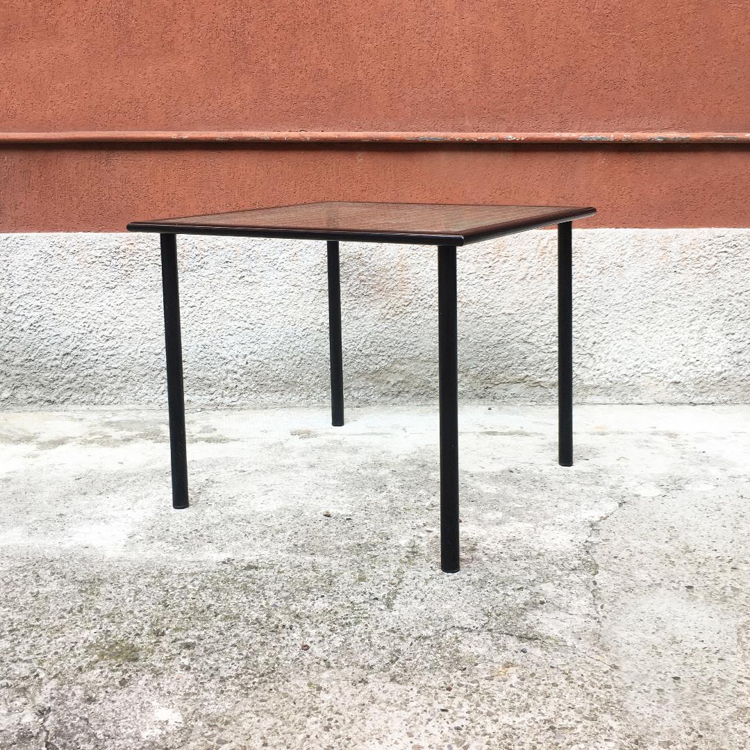 Italian Mid-Century Modern table with square-shaped squared glass, 1980s
Dining table with square-shaped squared glass top, housed on a black enameled metal structure with round section legs.
Good conditions.

80x80x72h cm.