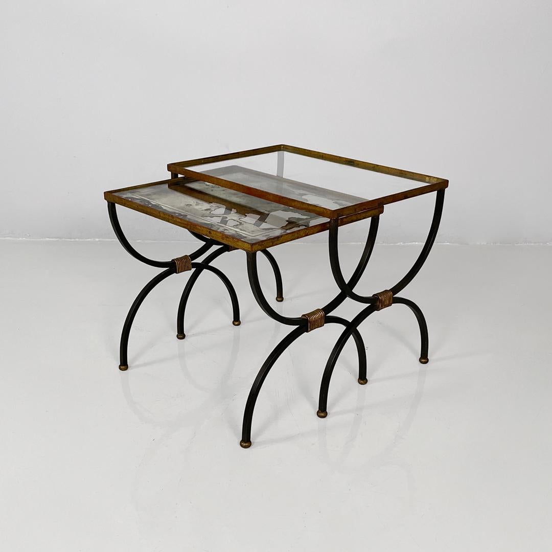 Italian mid-century modern stackable metal and glass coffee tables, 1940s
Pair of rectangular stackable coffee tables. The metal frame features two curved legs that taper in the center. The larger table has a clear glass top, while the smaller table