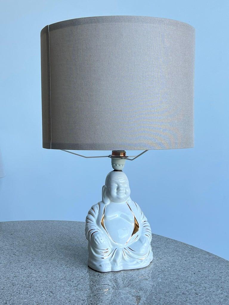 Lampada da tavolo italiana di metà secolo in porcellana dipinta a mano, a forma di Buddha, anni '60.
Lampada Buddha in porcellana dipinta a mano in oro, il paralume è stato sostituito con un paralume chiaro di forma rotonda.
Completamente ricablato