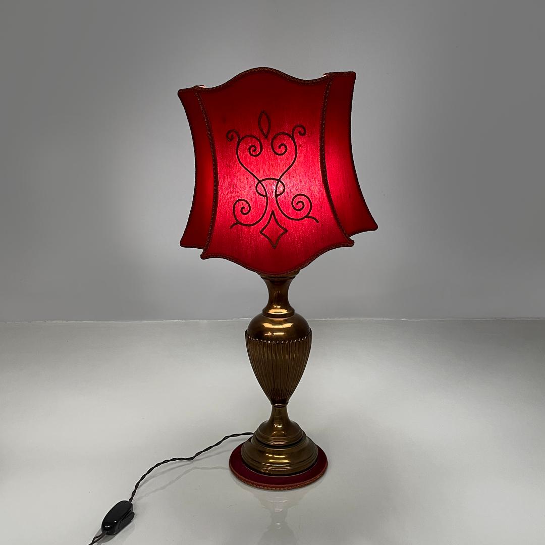 Italian mid-century modern table lamp red fabric shade with decorations, 1950s
Round base table lamp. The lampshade is in red fabric with brown edges, on the front it has a rounded decoration in brown trimmings. The decorated central stem is in