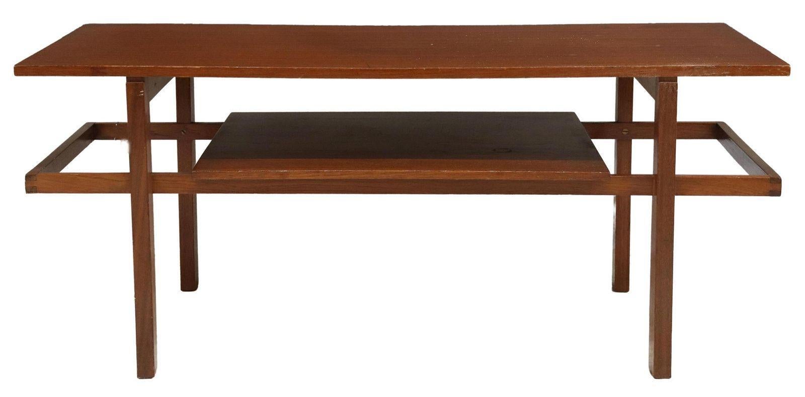 Table basse italienne en teck moderne du milieu du siècle, c.1960. Cette table présente un plateau rectangulaire, surmontant un plateau médian, reposant sur des pieds articulés.

Dimensions
environ 18.75 