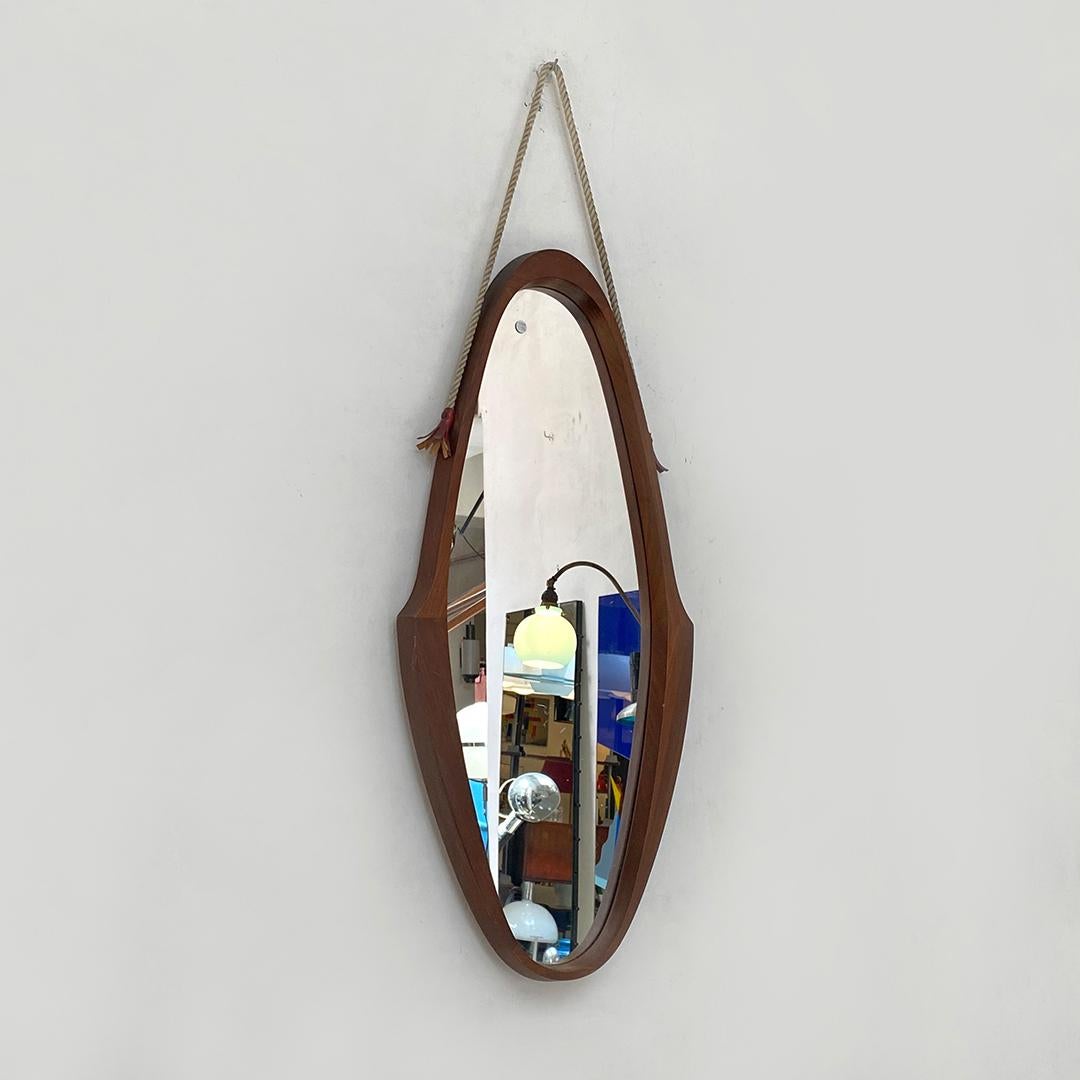 Italian Mid-Century Modern teak oval mirror with original rope, 1960s
Teak oval mirror, with teak frame and grooves, original rope for hanging the object on the wall, 1960s.

Excellent condition, some scratches on the glass.

Measures 36 x 82 H
