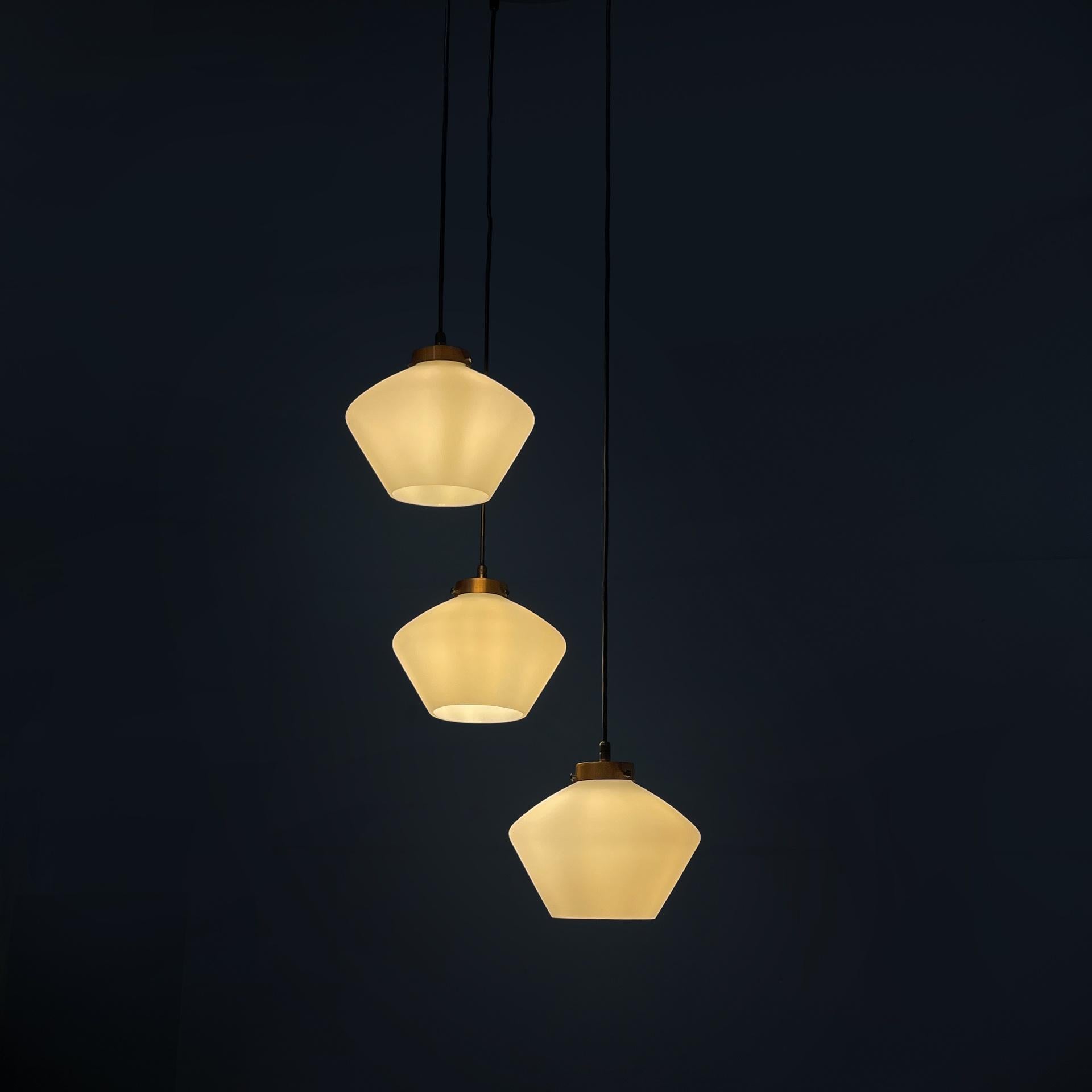 Lustre à trois lumières en verre et métal noir, Italie, milieu du siècle dernier, années 1950
Lustre à trois lumières avec diffuseurs en verre opalin et attache en cuivre. Les trois diffuseurs sont reliés par un câble noir à une fixation ronde en