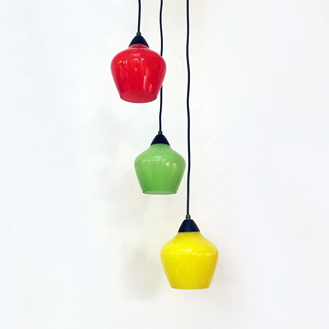 Italian Mid-Century Modern three-light chandelier with colored glass, 1950s
Three-light chandelier with black metal structure, from which the three electric cables start, with brass details and glass covered in yellow green and red, with white