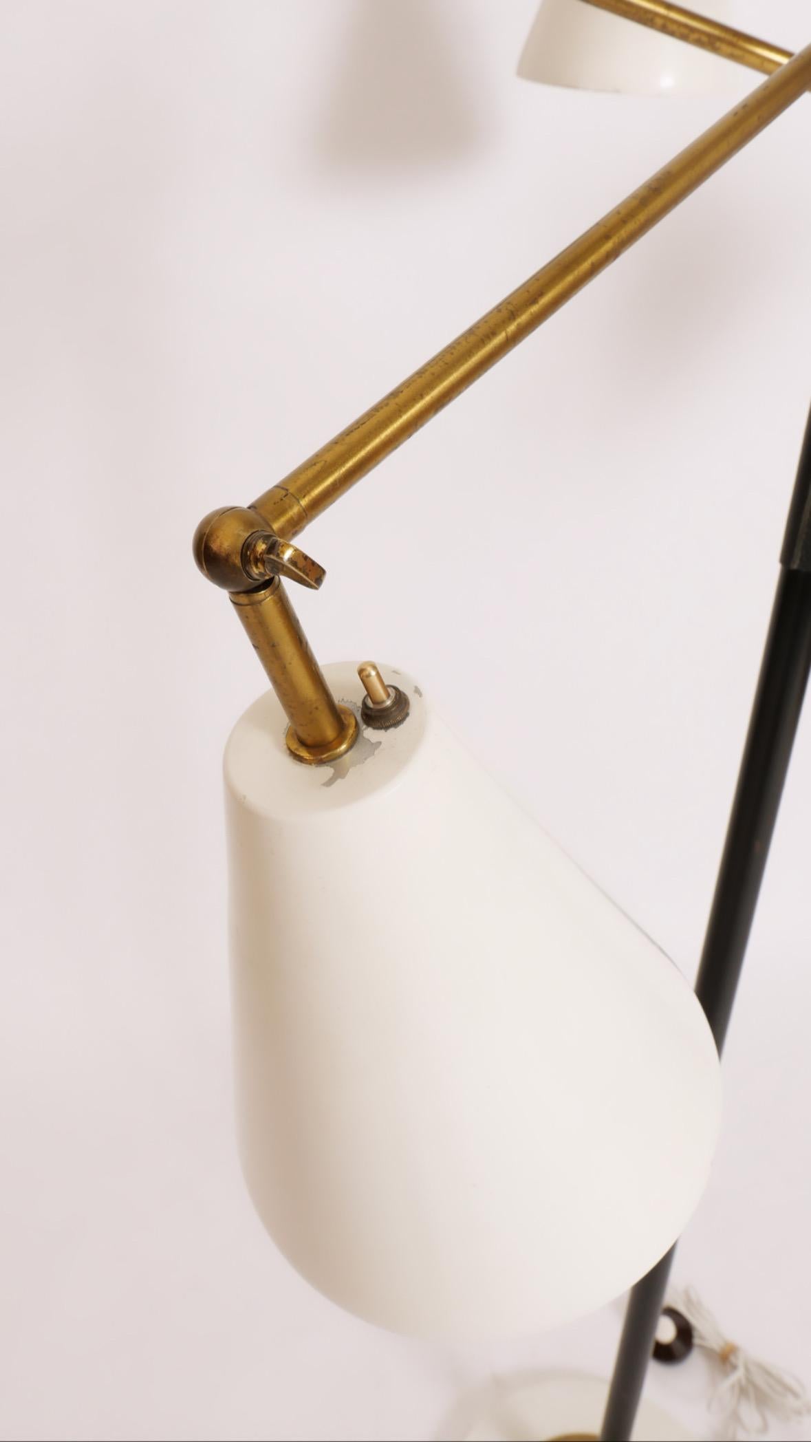 Iconic three-arm floor lamp in brass and black leather with marble base. Spun metal cone shades are factory-lacquered in original ivory paint. This lamp has been fully rewired and has new hand-stitched leather handles. The patina on the brass