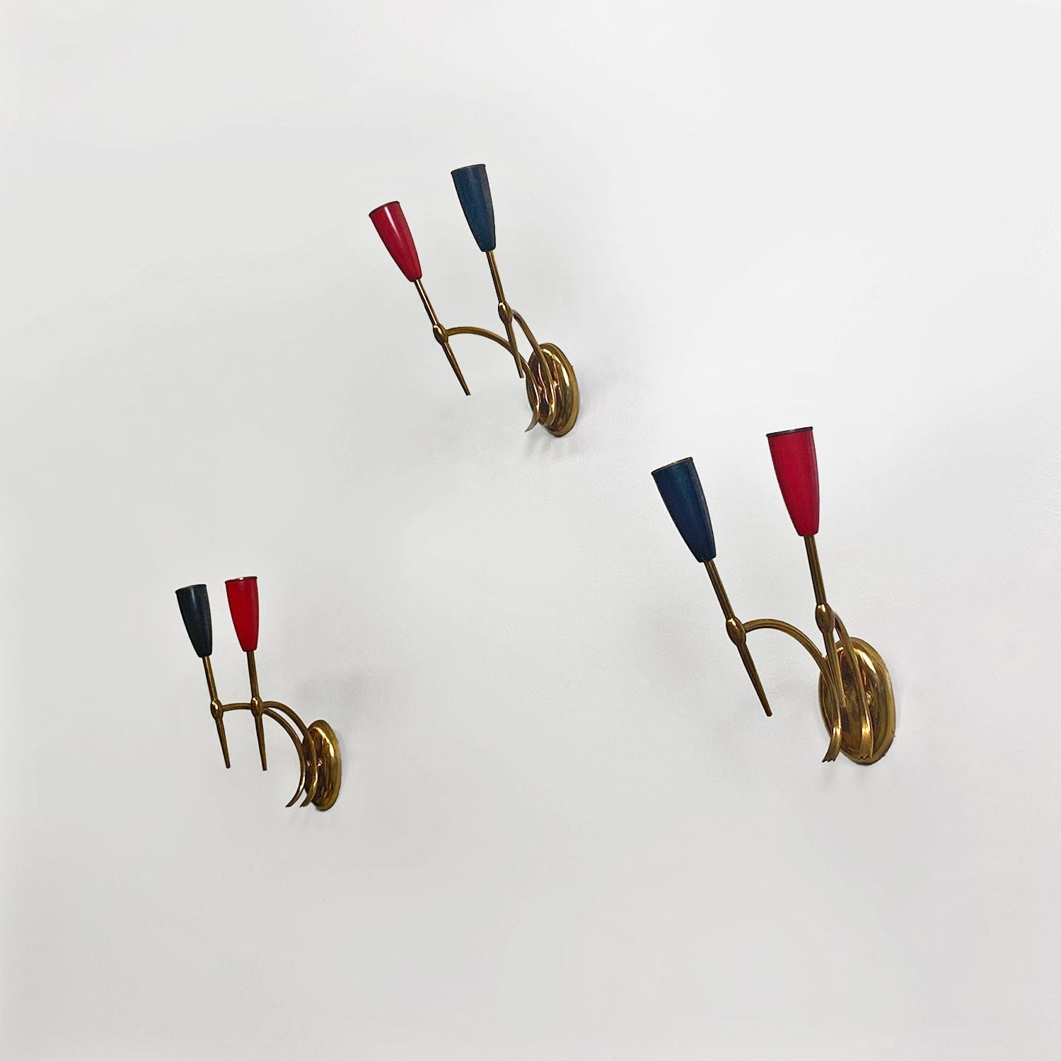 Italian mid-century modern two-arm brass wall lamps with cone lamp holder, 1950s.
Set of three wall lamps or sconces with two light points, with brass structure and respective cone lamp holders in red and black.
1950s
Good condition, scattered marks