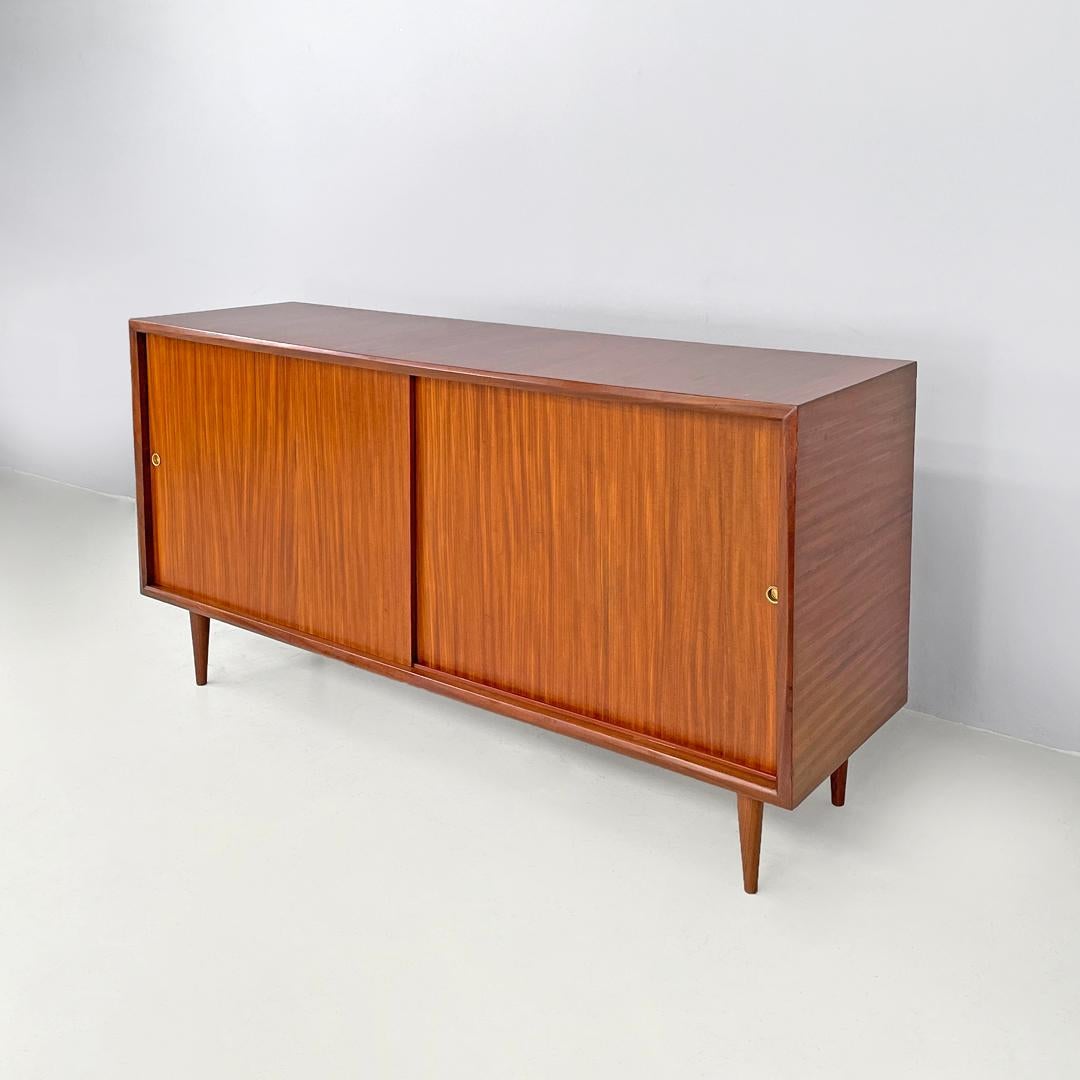 Credenza italiana di metà secolo a due ante in legno con maniglie in ottone, anni '60
Credenza con base rettangolare in legno. Ha due ante scorrevoli con maniglie rotonde in ottone, all'interno ci sono quattro scomparti divisi da un ripiano