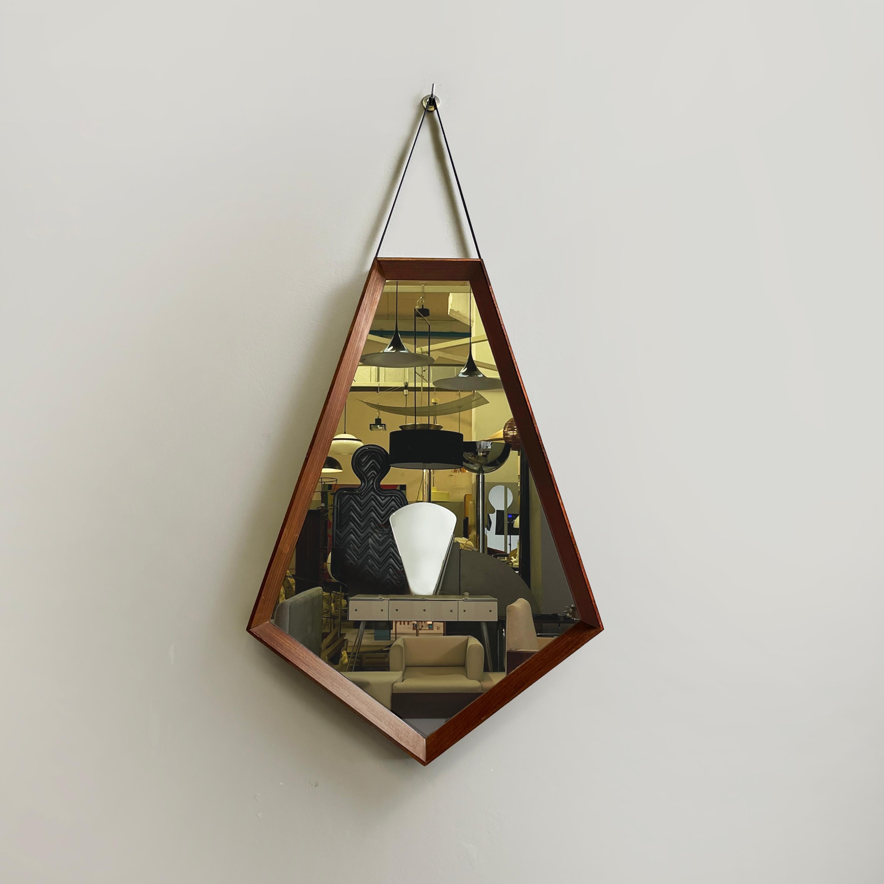 Italian mid-century modern Wall mirror in wood and black leather, 1960s
Wall mirror with thick wooden frame. The shape of the mirror is symmetrical and geometric, in fact it reminds a rhomboid. At the top it features a black leather strip.
1960