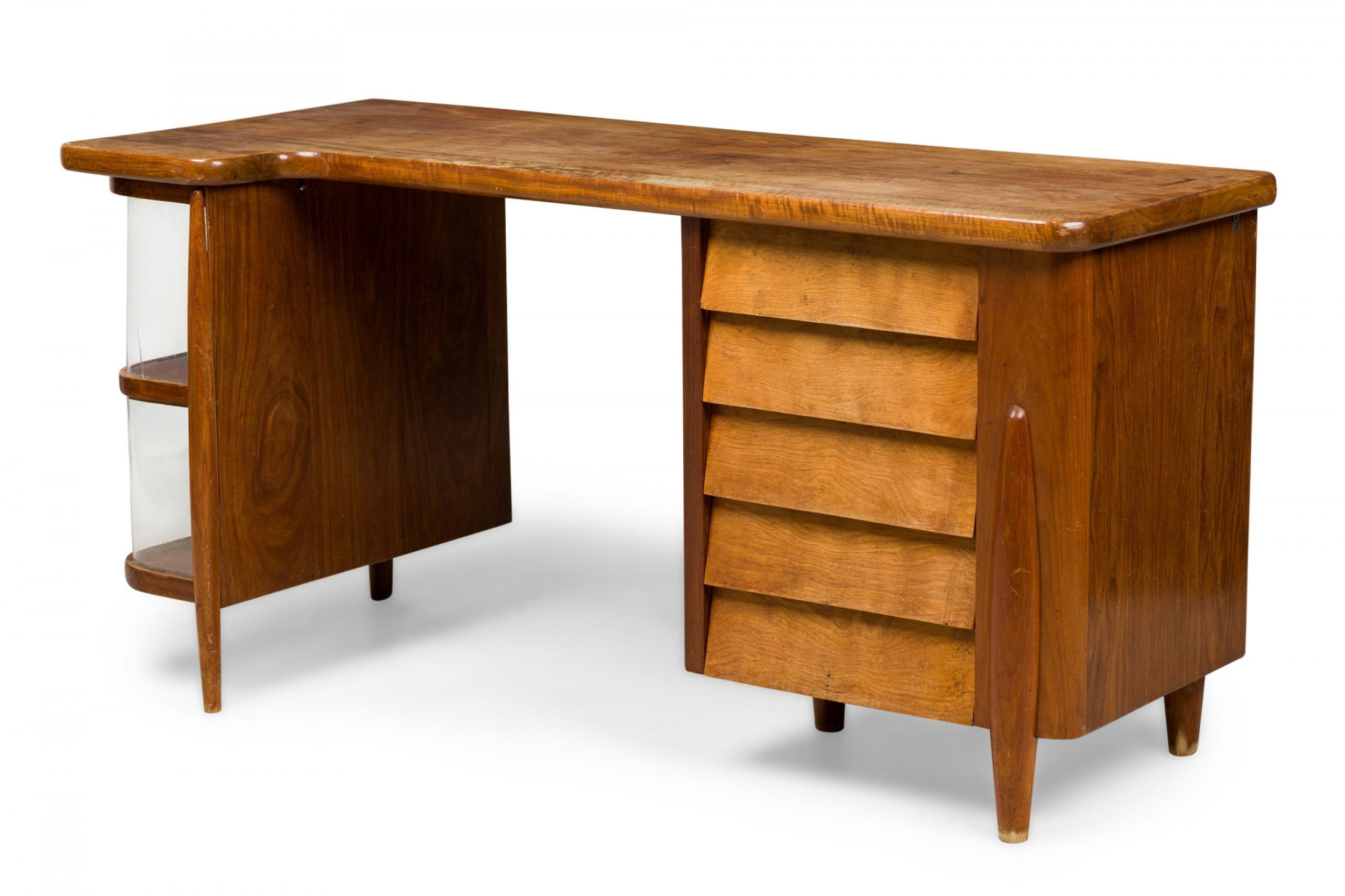 Italian Mid-Century Modern walnut desk featuring a slightly L-shaped top resting on a set of two open compartments with plexiglass supports on the left and 5 louver front drawers on the right, resting on tapered integrated legs. (manner of GIO PONTI)
