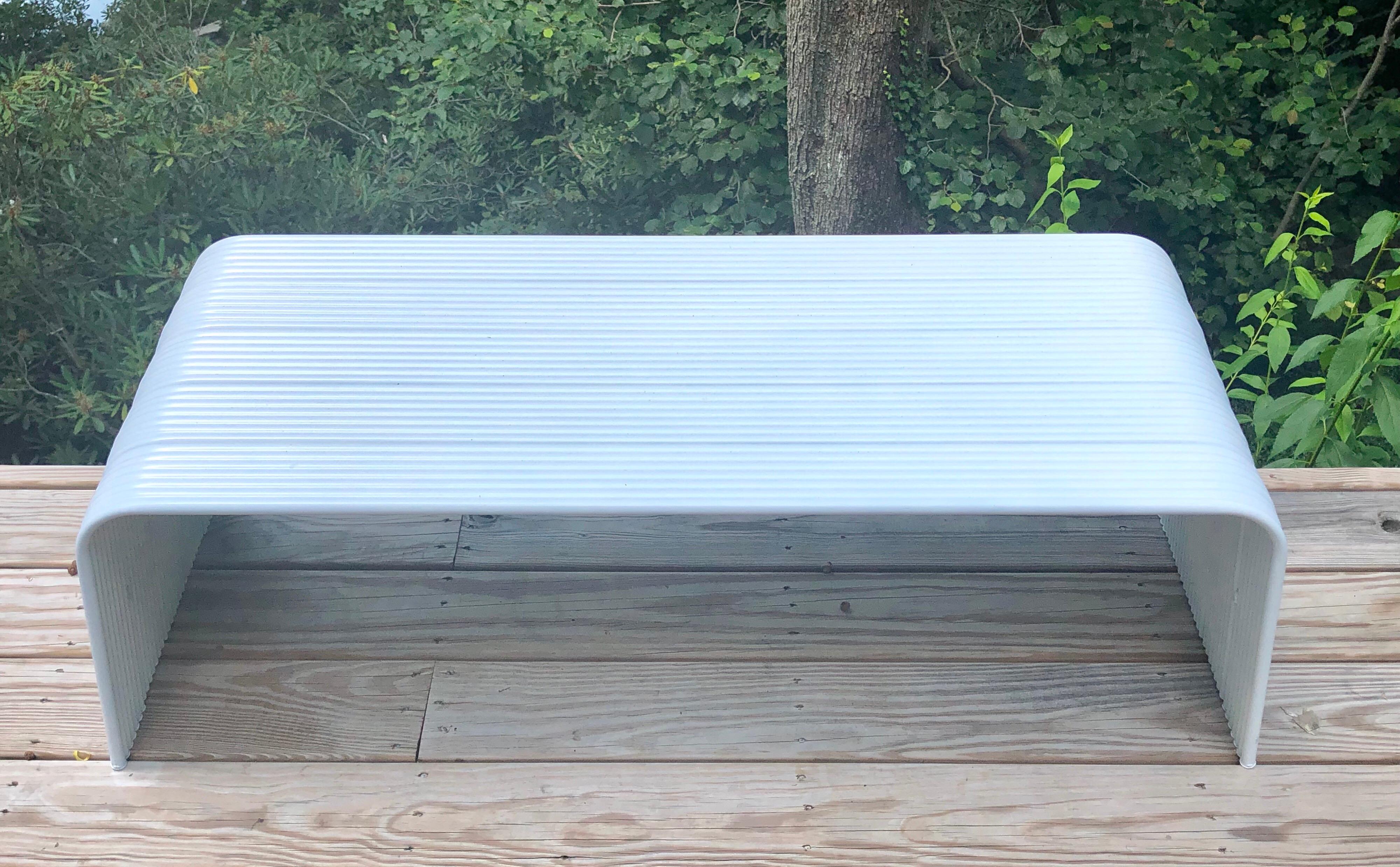 Italian Mid-Century Modern white enameled aluminum bench attributed to Superstudio.

The bench is in reverse U-shaped form and composed of a series of grooved pieces of aluminum. It is light and designed to be easily transported as they will