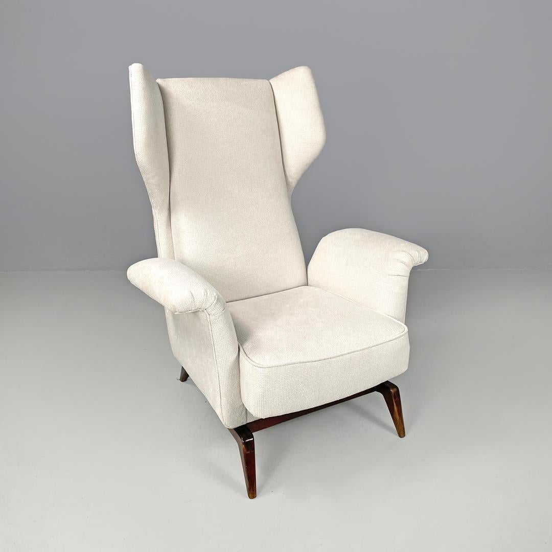 Italian mid-century modern white fabric and wood armchair with headrests, 1950s
Armchair upholstered in white fabric tending towards beige. The backrest has two lateral headrests in the upper part, the armrests develop by curving outwards. The
