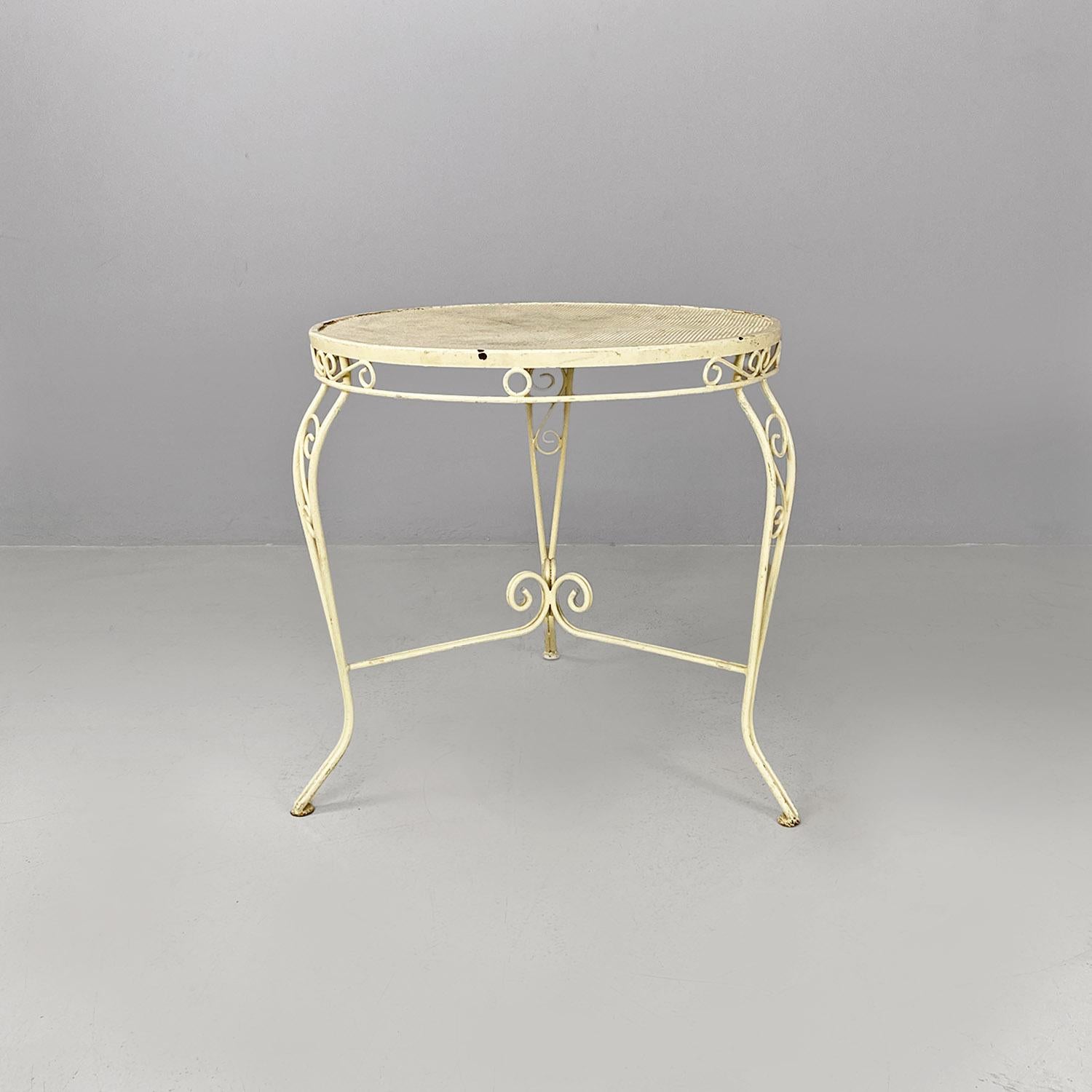 Tavolo da giardino rotondo in ferro battuto bianco, anni '60.
Tavolo da pranzo da giardino, ma adatto anche all'uso domestico, interamente realizzato in ferro battuto verniciato bianco crema. Il piano è in metallo tondo microforato con il bordo e le