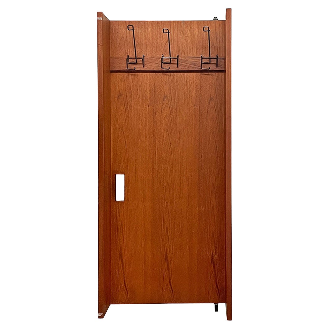 Armadio a muro in legno e metallo nero della metà del secolo scorso con ganci, anni '60.
L'armadio a muro è sostenuto da un'asta di ferro nero a forma di C, che lo tiene ancorato alla parete e permette di aprire la parte in legno per riporre vestiti