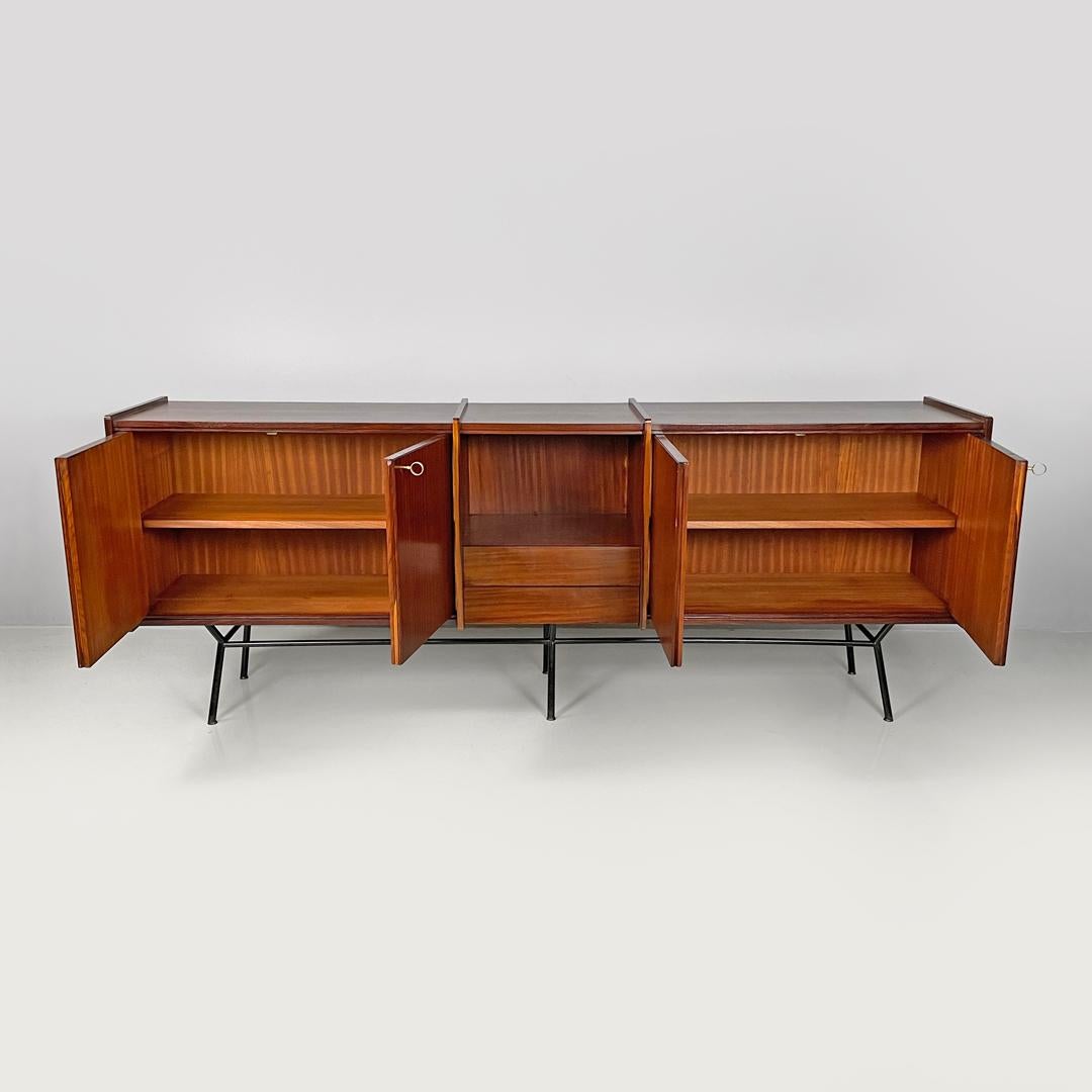 Italian mid-century modern wood and brass sideboard with drawers and doors 1960s
Sideboard or wooden sideboard. The structure has four doors, two on each side, with a working brass key that opens onto two compartments divided by a central shelf. In