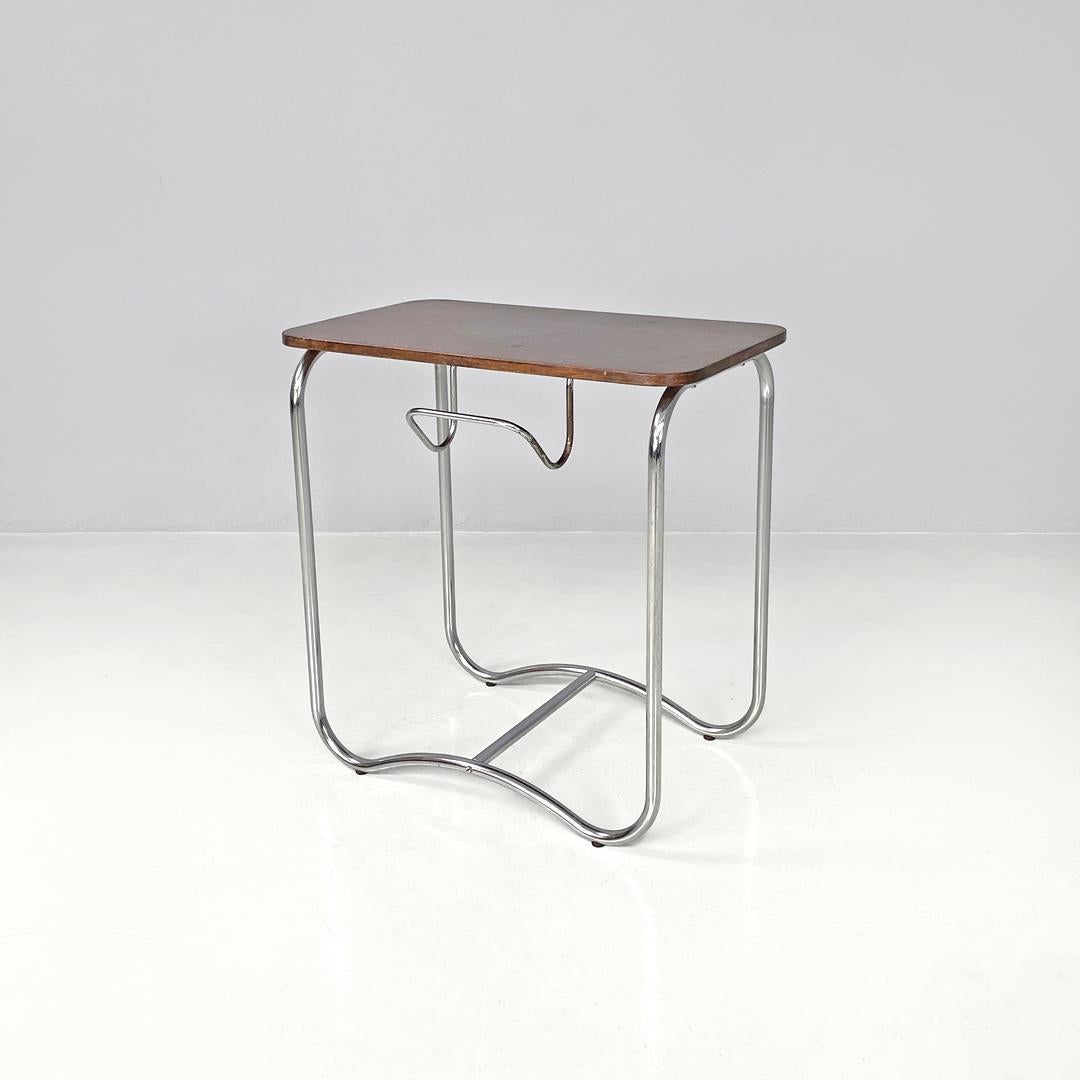 Italian mid-century modern wood and metal coffee table with newspaper hook 1950s
Coffee table with rectangular wooden top. The structure is made of chromed metal rod, the four legs extend to the ground to then create two arches joined by a central