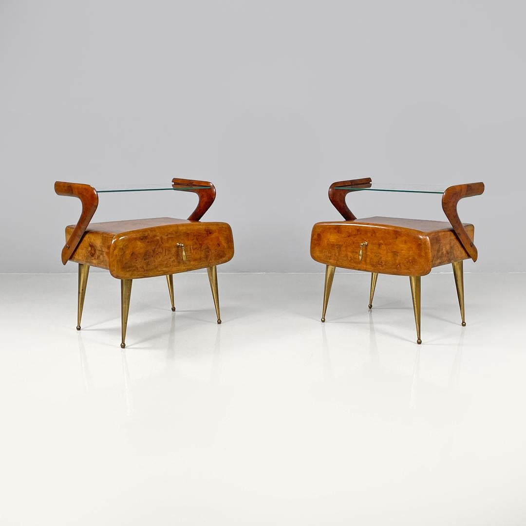 Italian mid-century modern wooden and brass nightstands with glass top, 1950s
Pair of bedside tables with glass tops. The structure is made of wood with rounded profiles as are the drawers, which have the wider front part of the same structure and