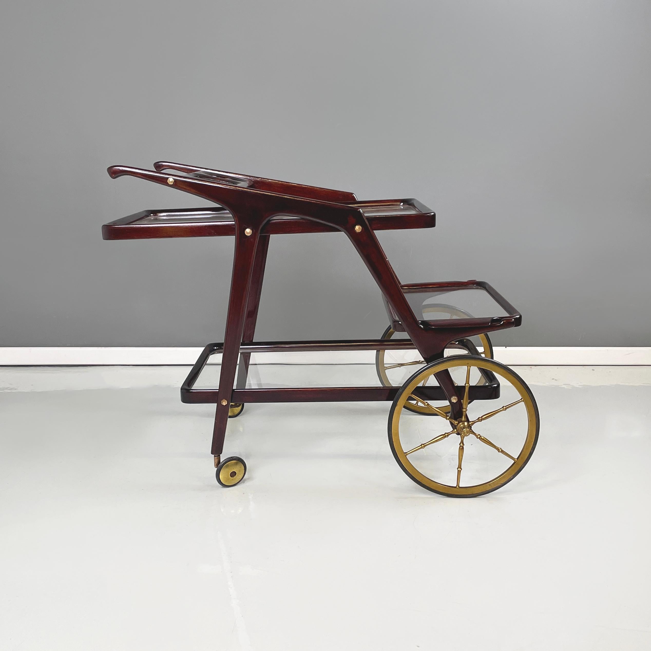 Italian mid-century modern Wooden and glass cart with tray by Cesare Lacca, 1950s
Food cart with dark wooden structure. There are two shelves and an extractable tray with handles made of glass with wooden profiles. In the upper part it has 3 holes