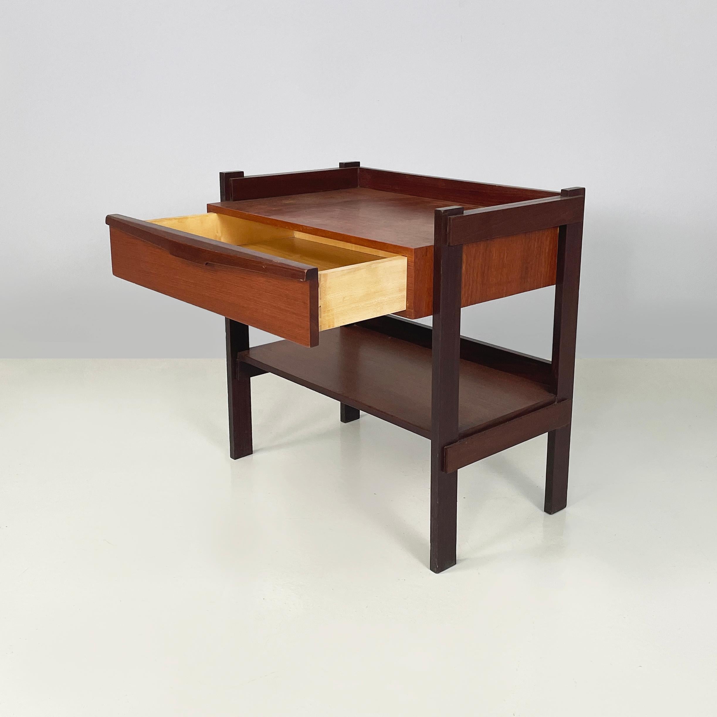 Italian mid-century modern Wooden coffee table with shelves and drawer, 1960s
Coffee table with double rectangular shelf, entirely in dark wood. There is a drawer on the front. The two shelves have a raised edge. The structure is made up of wooden