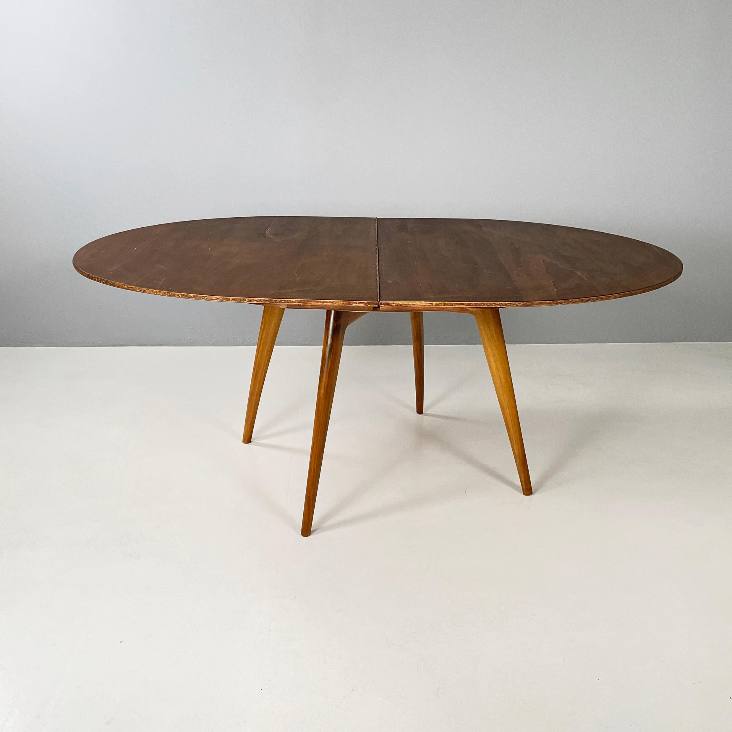 Italian mid-century modern Wooden dining table with extension, 1960s
Dining table entirely in wood. The top can be round or, using the extension, oval. Round section legs.
1960 approx.
Good condition, the extension shows signs of use. the round top