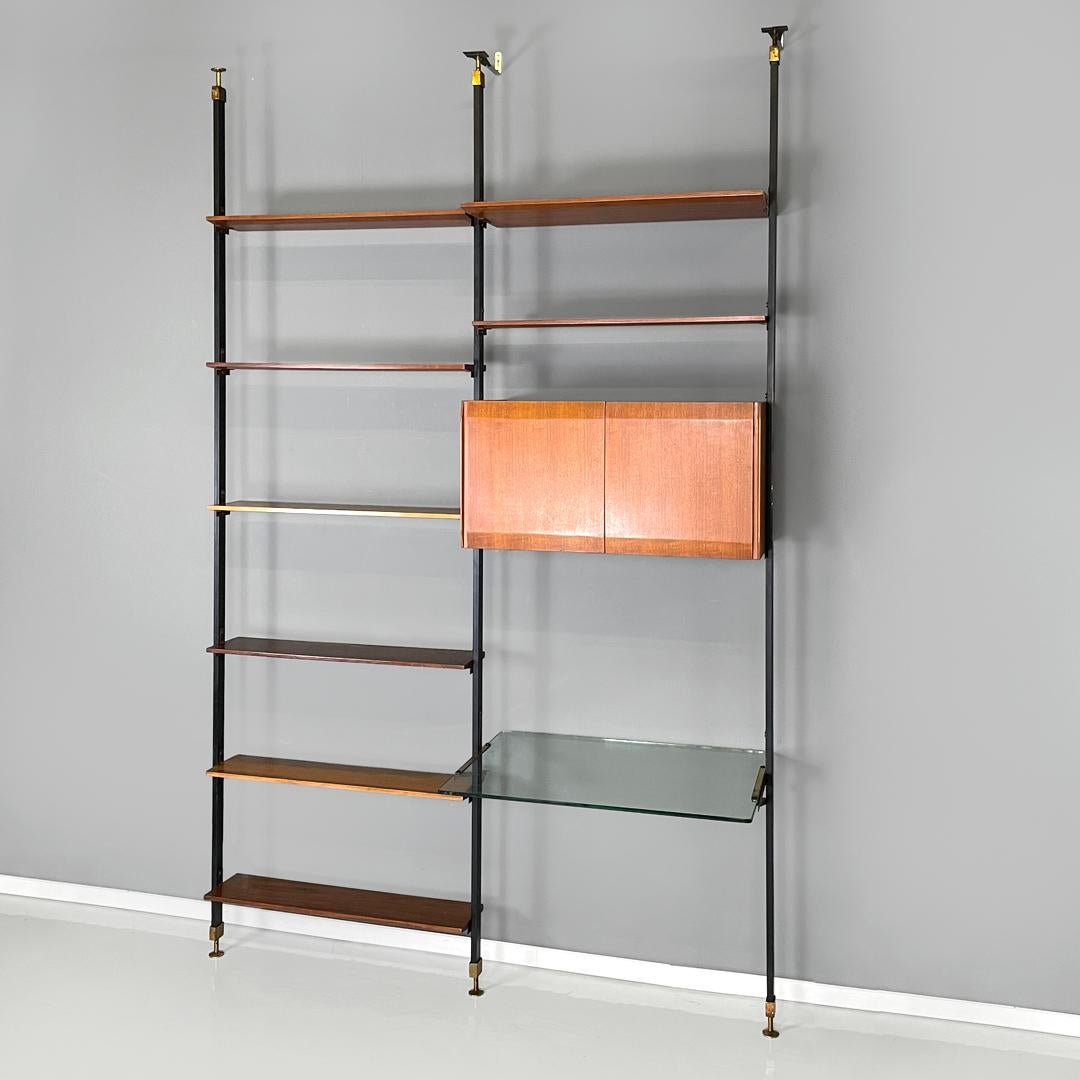 Italian mid-century modern wooden floor-to-ceiling bookcase with glass top 1960s
Floor-to-ceiling wall bookcase in wood and black metal. The load-bearing structure is made up of three square-section uprights, a cabinet with doors, a glass top that