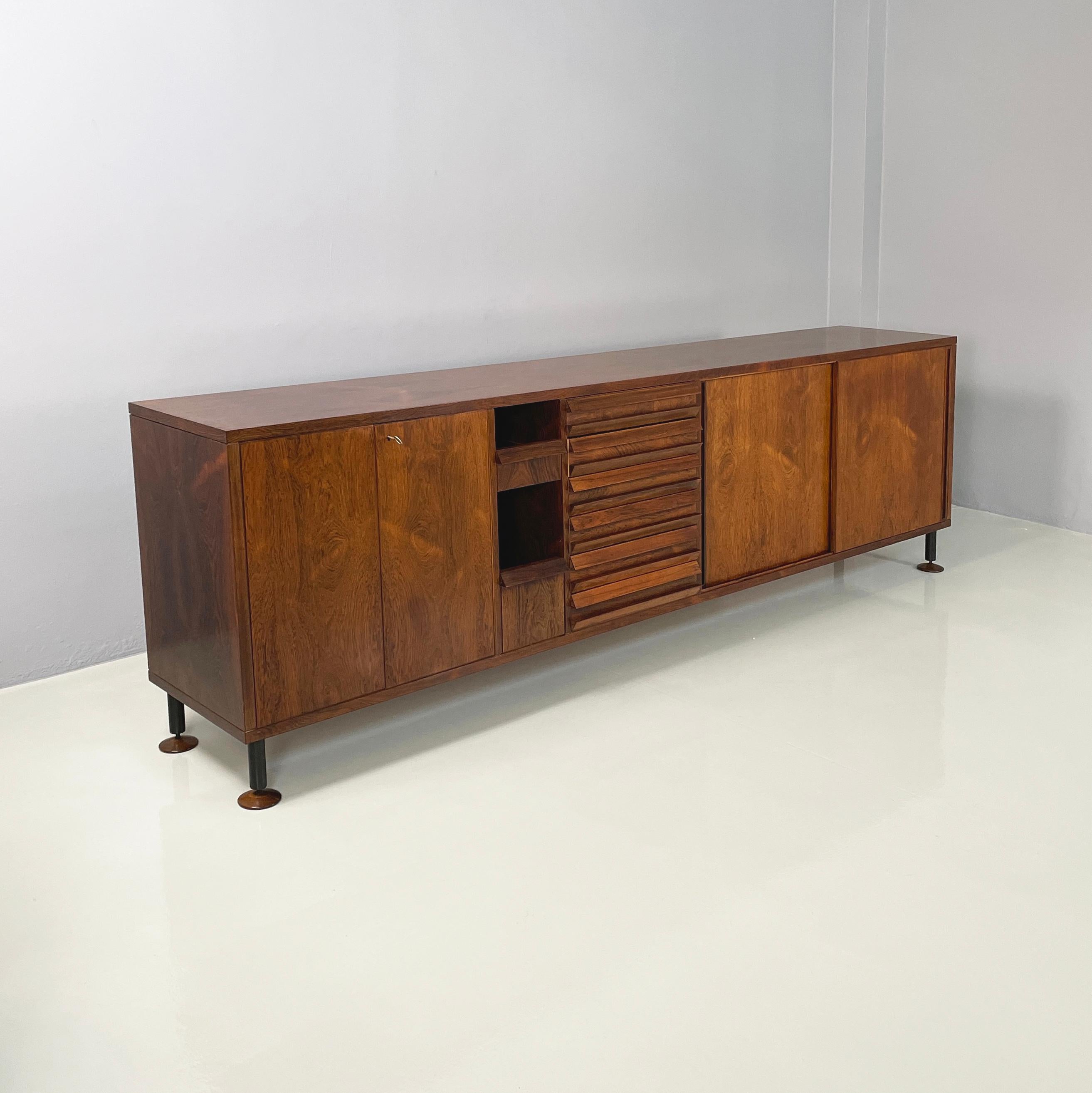 Italian mid-century modern Wooden sideboard with drawers and shelves, 1960s
Sideboard with rectangular base made entirely of wood. On the front it has several compartments: one with a red-burgundy painted internal shelves and 2 hinged doors, two