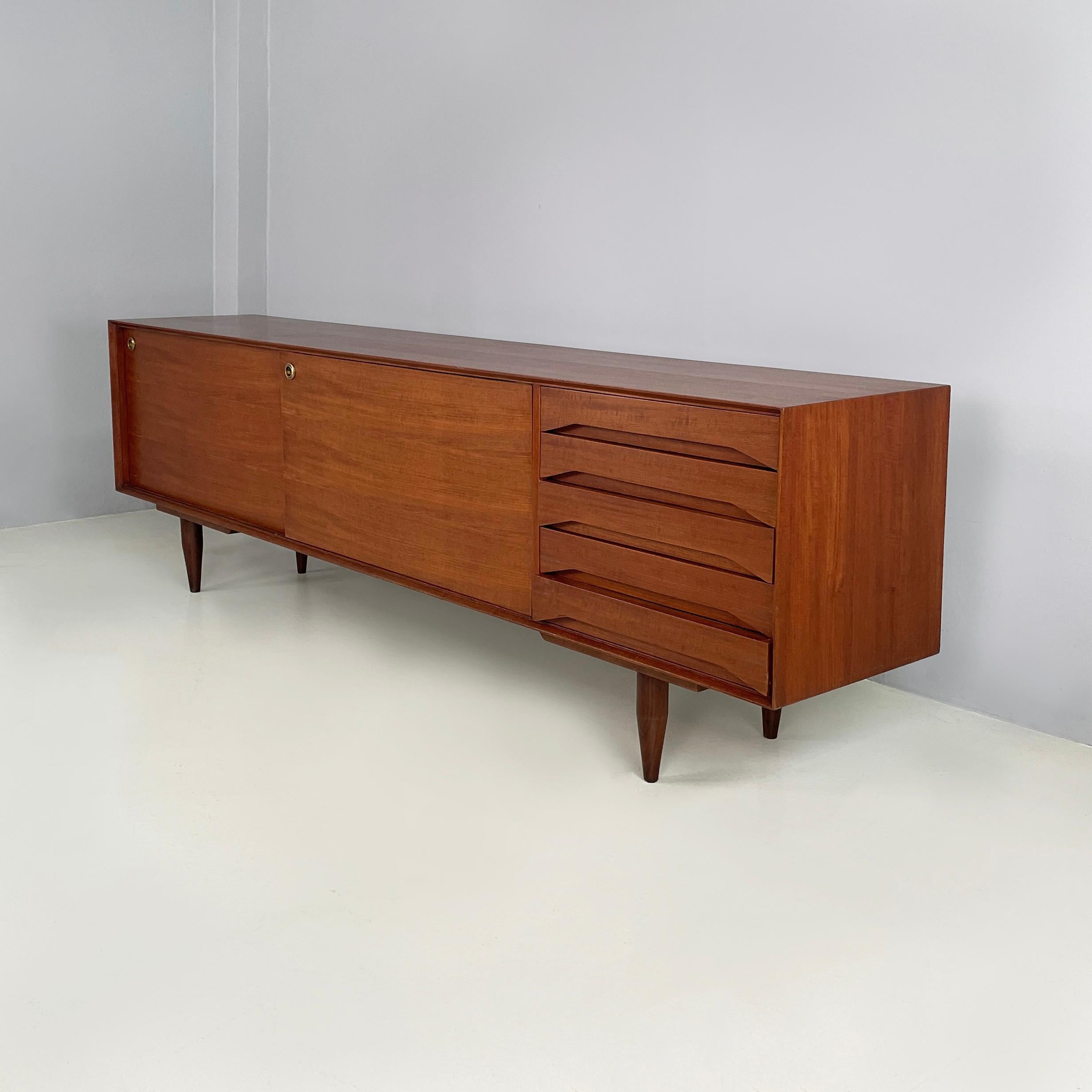 Buffet italien en bois avec tiroirs et portes coulissantes, années 1960
Buffet avec base rectangulaire en bois. D'un côté, il y a deux portes coulissantes avec une étagère à l'intérieur. Poignées rondes en laiton. De l'autre côté, il y a 5 tiroirs