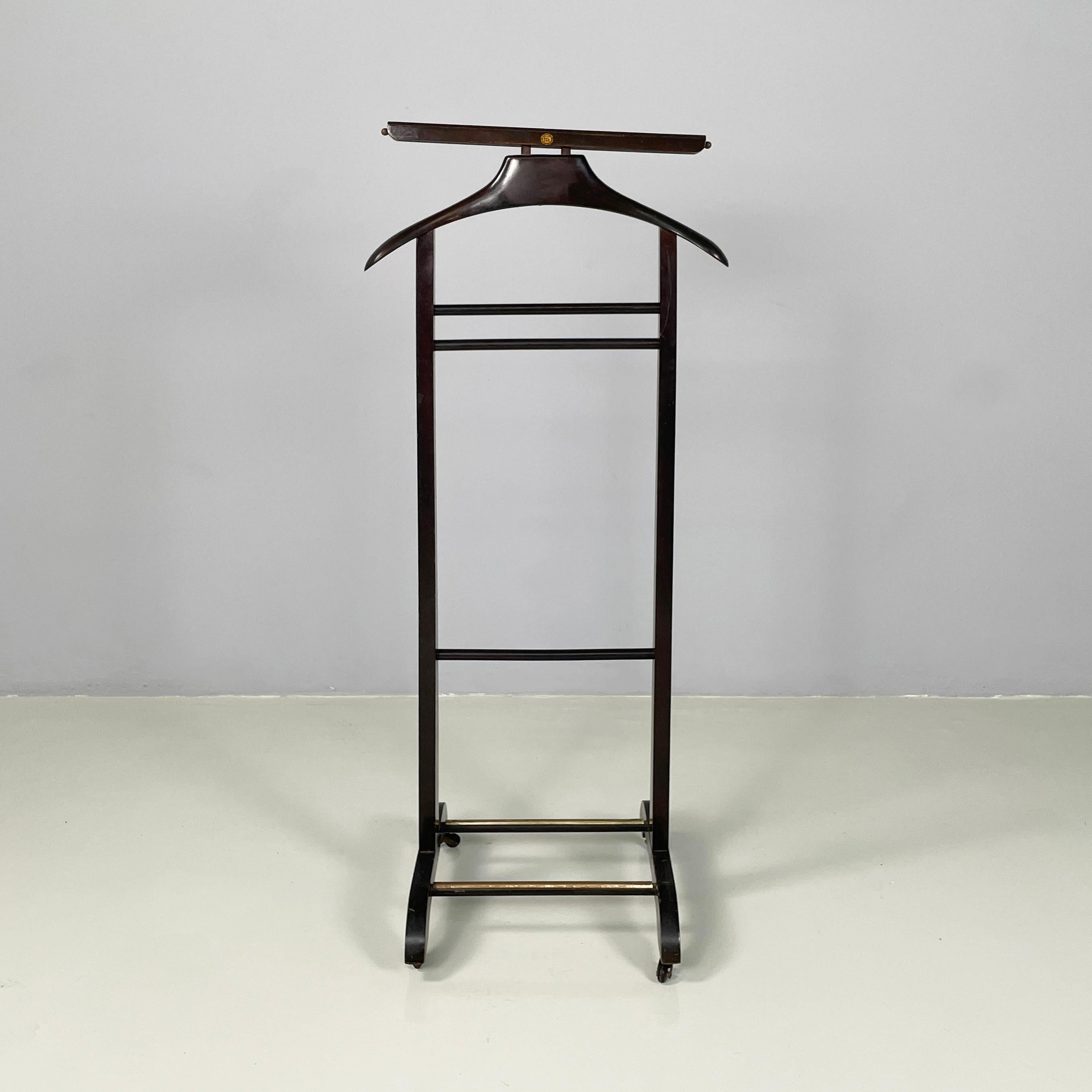 Italian mid-century modern Wooden valet stand by Fratelli Reguitti, 1950s
Iconic and vintage floor valet stand in wood with brass details. In the upper part there is a coat hanger. The structure is composed of two square-section slats, joined by