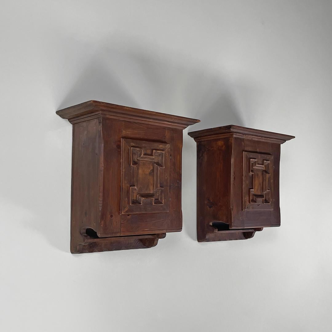 Italian mid-century modern wooden wall nightstands with decorated doors, 1960s
Pair of wall-mounted bedside tables made entirely of wood. The top is rectangular, with a round hook to hang them on the wall. The bedside tables have a front door