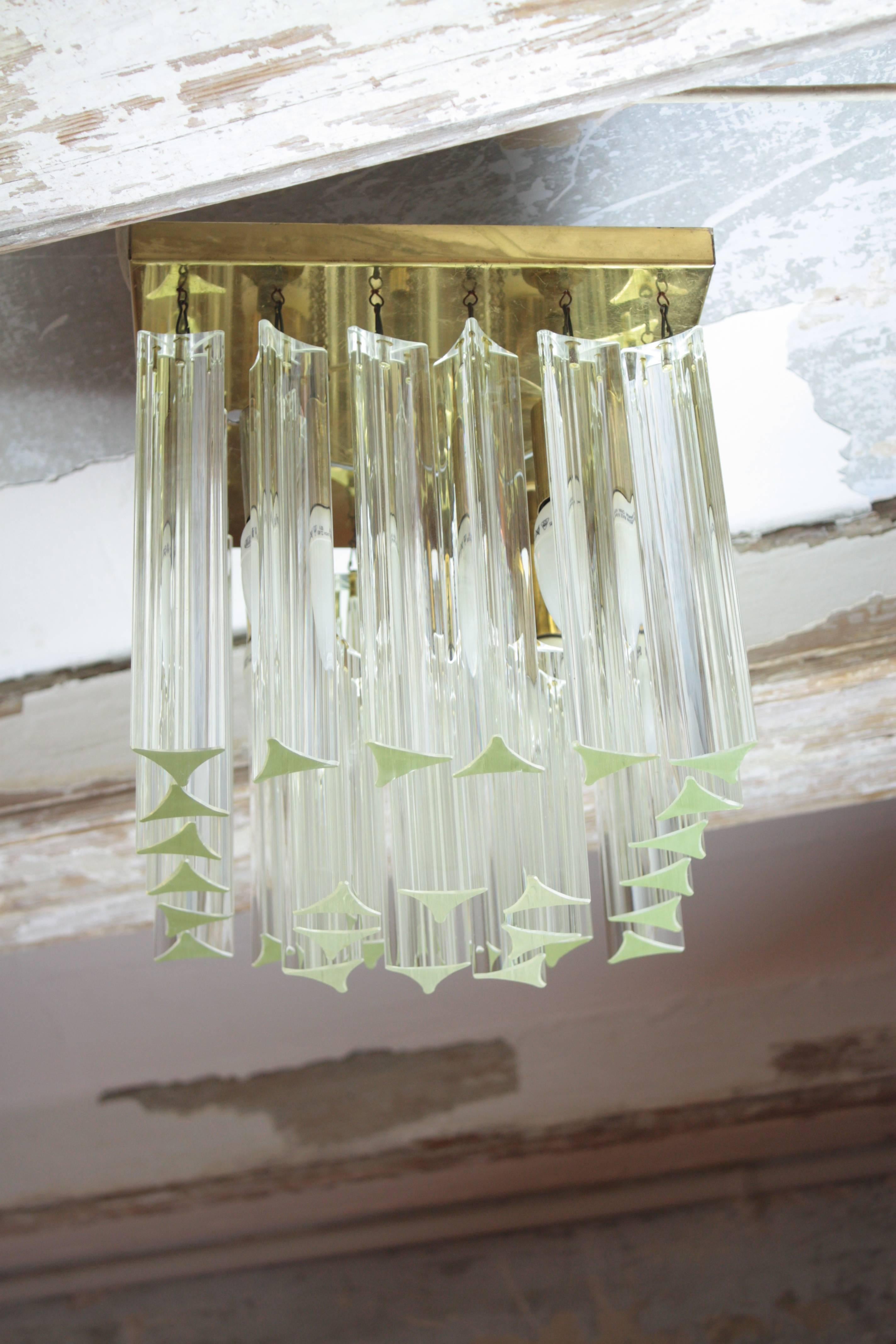 Mid-Century Modern crystal flush mount ceiling sconce or chandelier. Attributed to Camer Glass, 1970s.
This ceiling sconce consists of 20 large and eight small triedre crystals suspended from a brass squared base.
It has five E14 bulbs and it is new