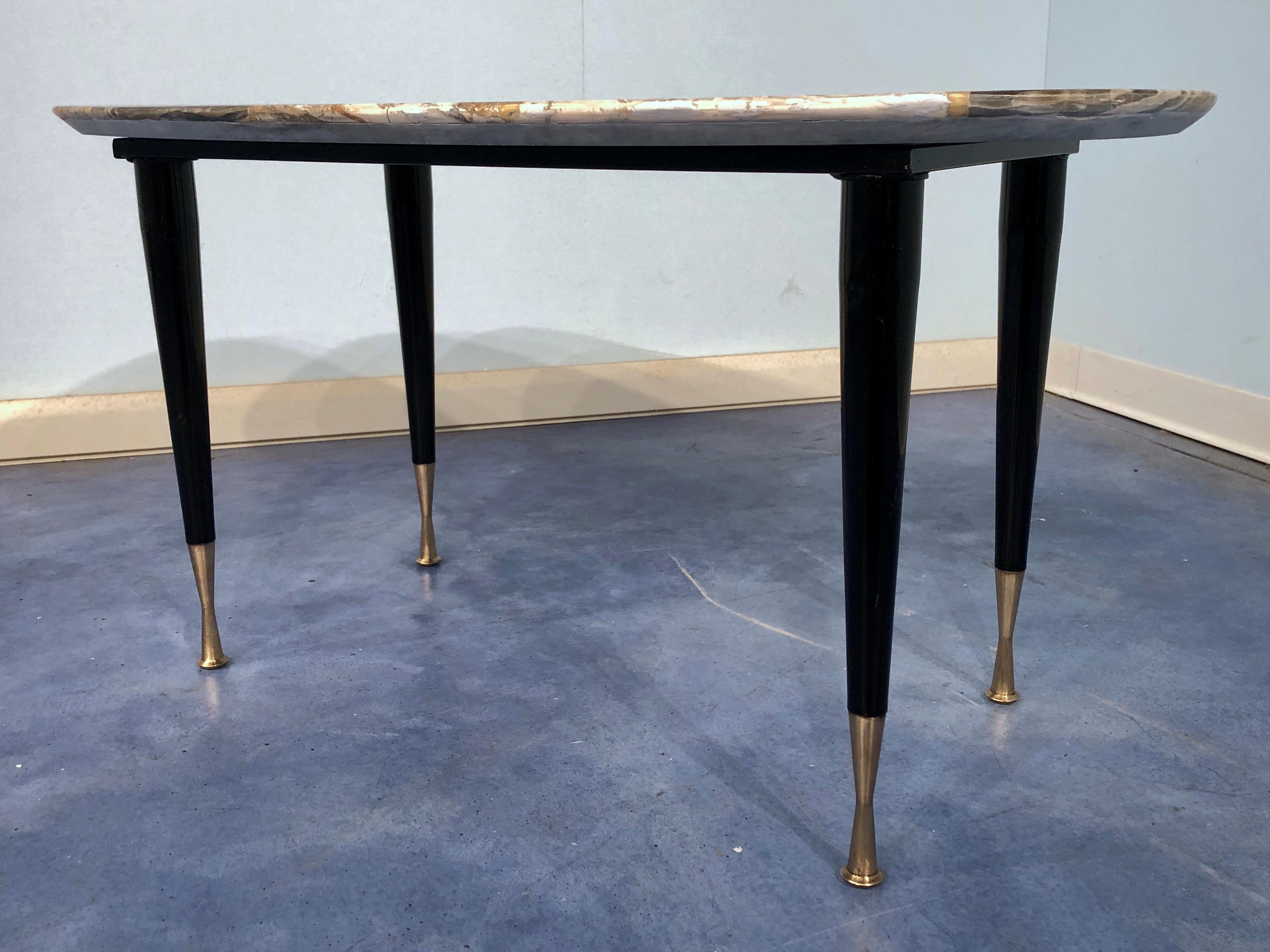 Charming and very elegant Italian midcentury mosaic marble coffee table, in dark and light colors.
Black lacquered legs in metal with brass-plated sabot on the feet.
             
