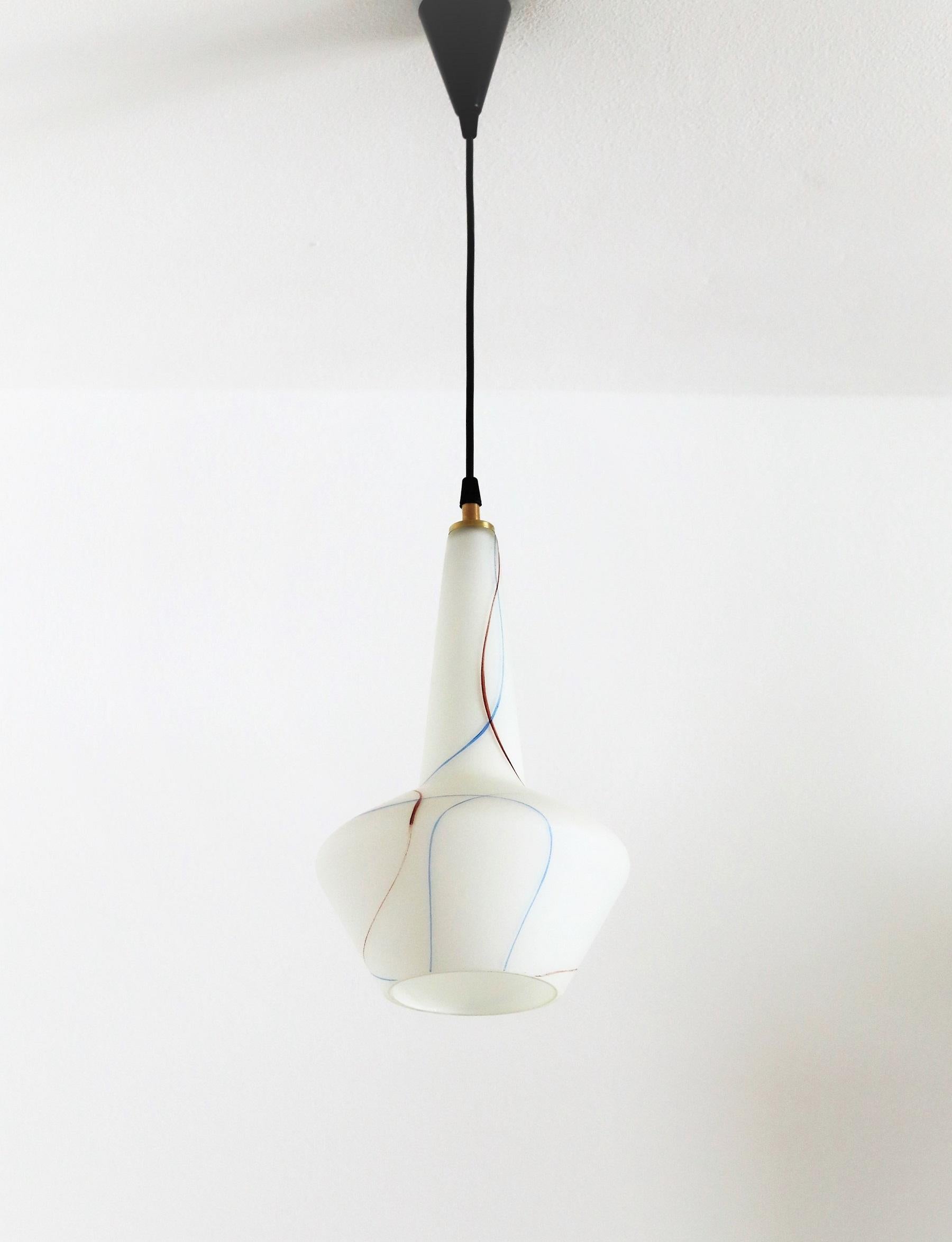 Beautiful tiny pendant lamp made of Murano glass in Italy during the 1970s.
The glass part is hand-crafted in white glass with red and blue irregular stripes within the glass. You can see the glass is made of more layers. (take a closer look to the