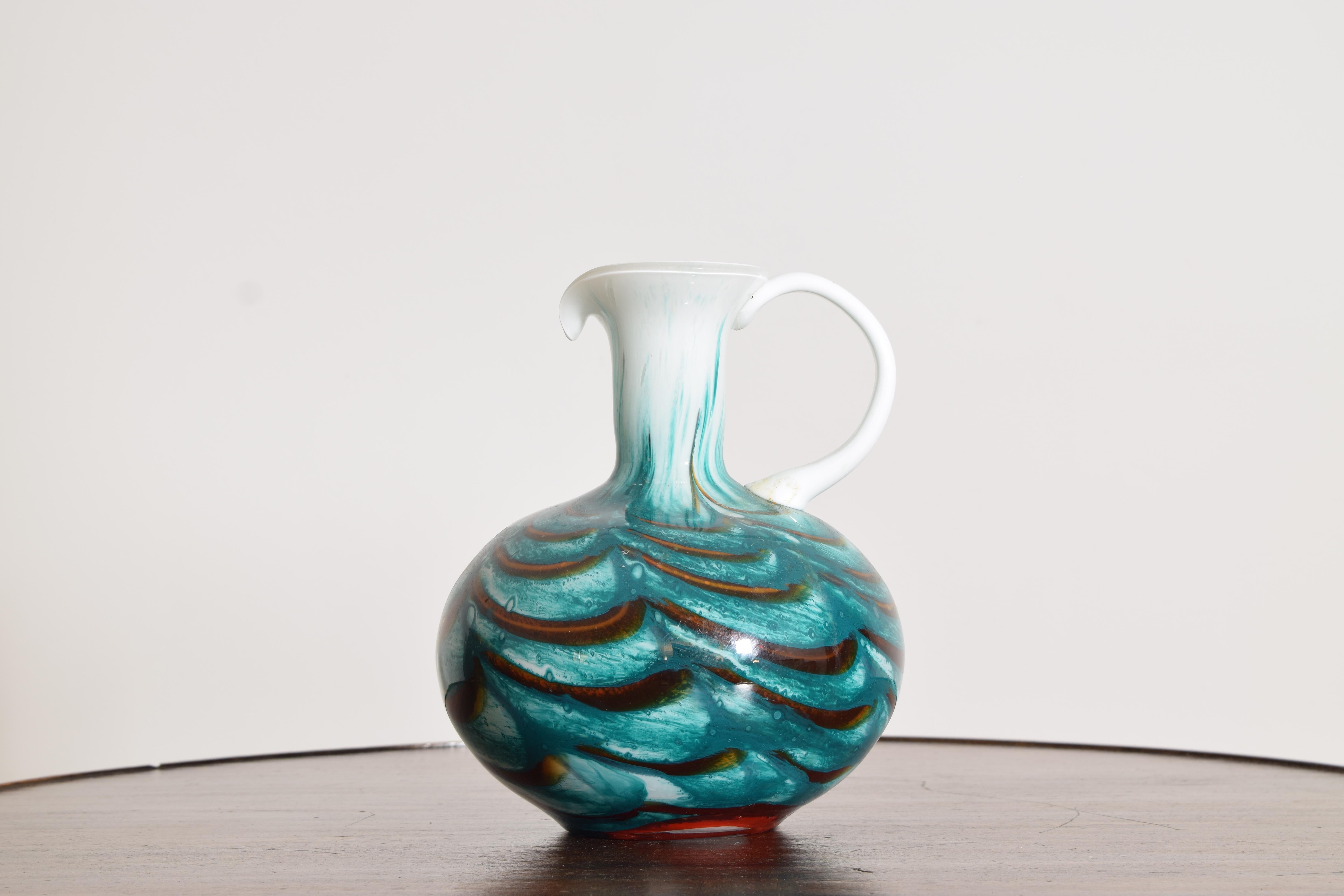 Handblown glass pitcher with swirling teal, white, and amber coloration, flared spout, and applied handle. Likely Murano, mid-20th century. Polished pontil; light wear consistent with age.