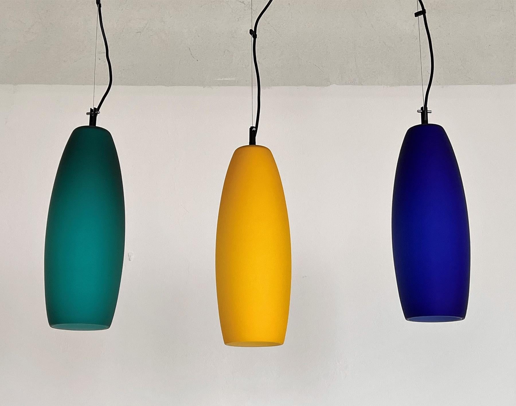 Beautiful set of three satin frosted glass pendant lights in different colors: blue, green and yellow.
All three glasses have a white inside glass layer.
Made in Murano, Italy, in the late mid-century of the 1970s, by De Majo Murano. The blue