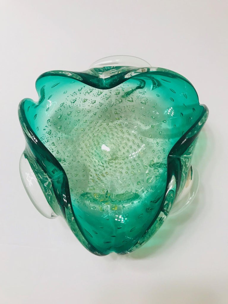 Mid-Century Modern Venetian glass bowl or ashtray with organic floral form. Exquisitely handblown in hues of emerald green. Bowl has bubble glass base design with white gold fleck accents. Features pinched rims with flared sides.