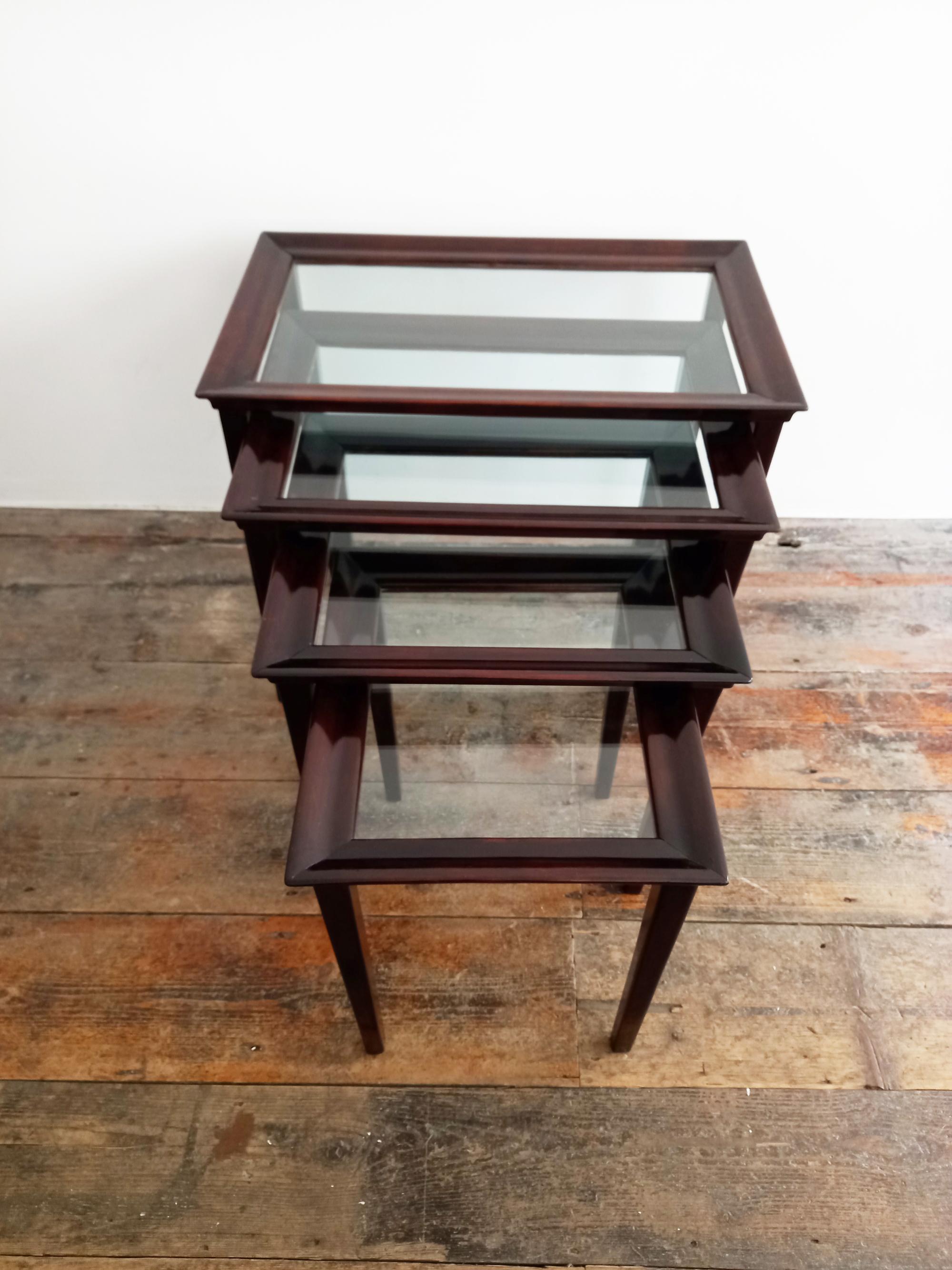 Very elegant side tables. Mid-century, set of four Nesting Tables in stained Mahogany wood and glass top. Italy 1960s