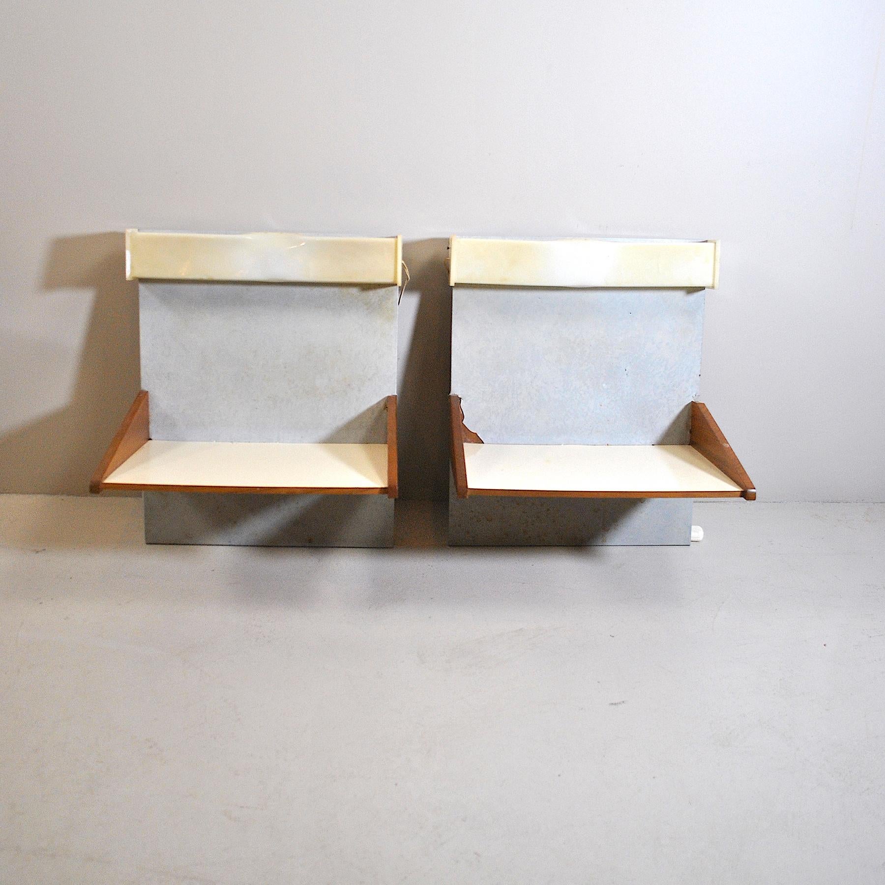 Pair of wall-mounted wooden bedside tables with lights incorporated in a plexiglass structure.