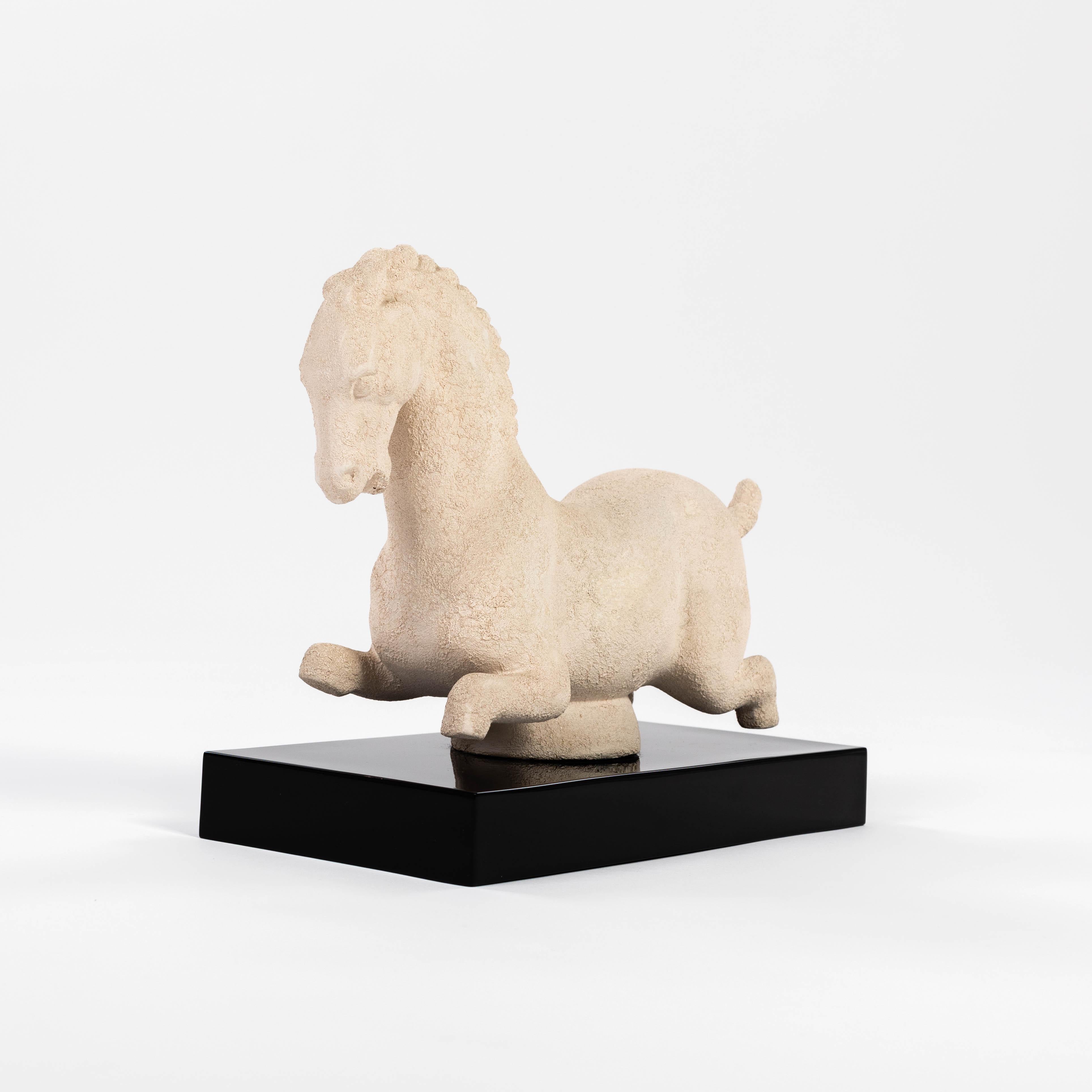 A stylized ceramic horse on a black lacquered wooden base. 
The ceramic has a matte, open-pored and grainy surface, the forms are soft.
The striking high gloss lacquered wooden base (lacquer renewed) 
provides a perfect presentation surface for the