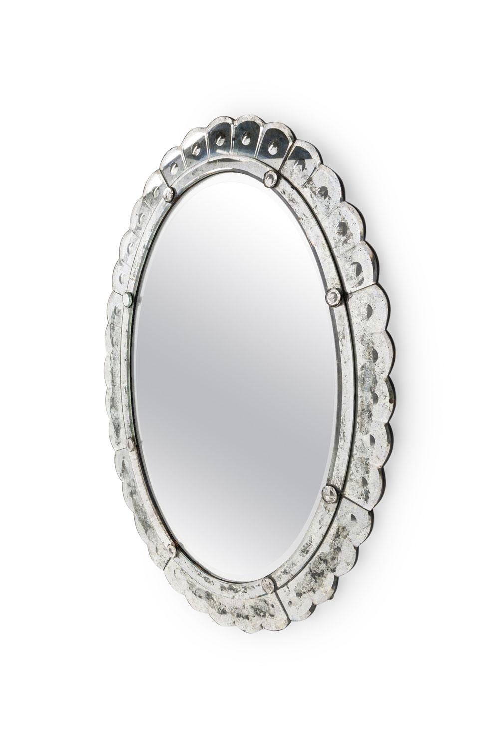 Espejo biselado italiano de mediados de siglo de forma ovalada con marco de borde festoneado desilverizado

Desplomado intencionado del borde exterior