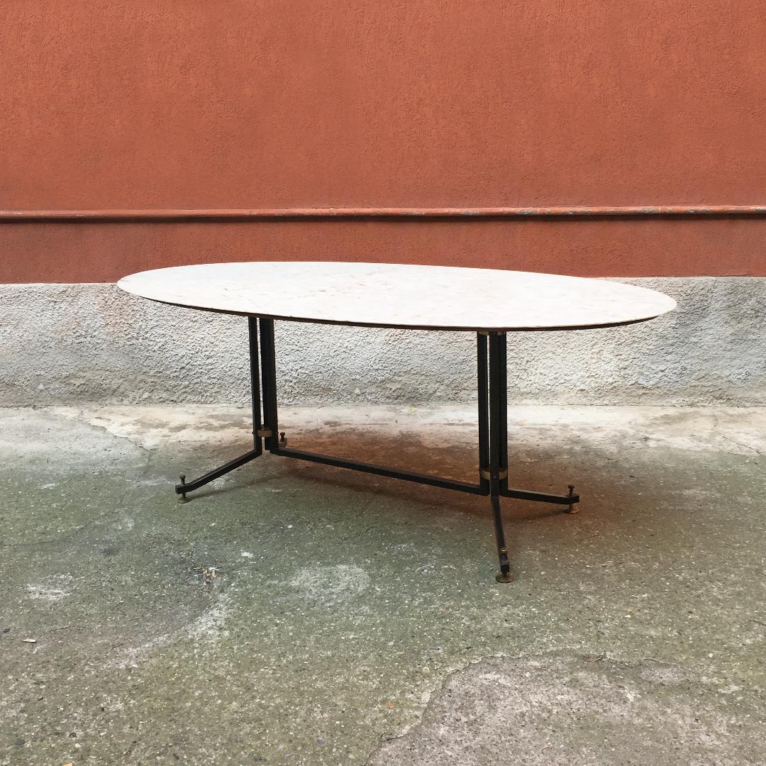 Italian Mid-century oval table with Portuguese pink marble top, 1950s
Oval table with Portuguese pink marble top, with bevel along the perimeter, which rests on its original wooden top. Black metal structure with round brass ferrules and