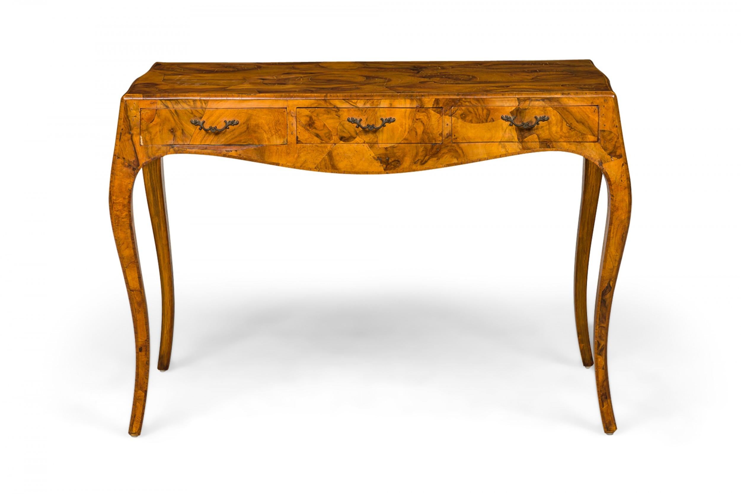 Italian mid-century rectangular writing table with oyster burl veneer and three drawers with brass drawer pulls, resting on four cabriole legs.
   
